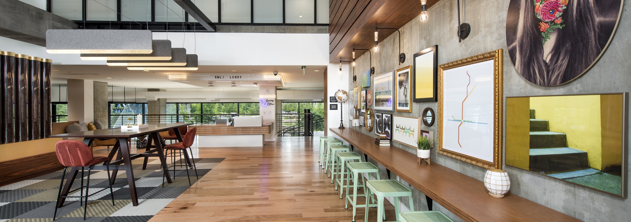 Interior view of AMLI Lenox clubhouse with multiple seating areas and wood floors and brightly colored artwork