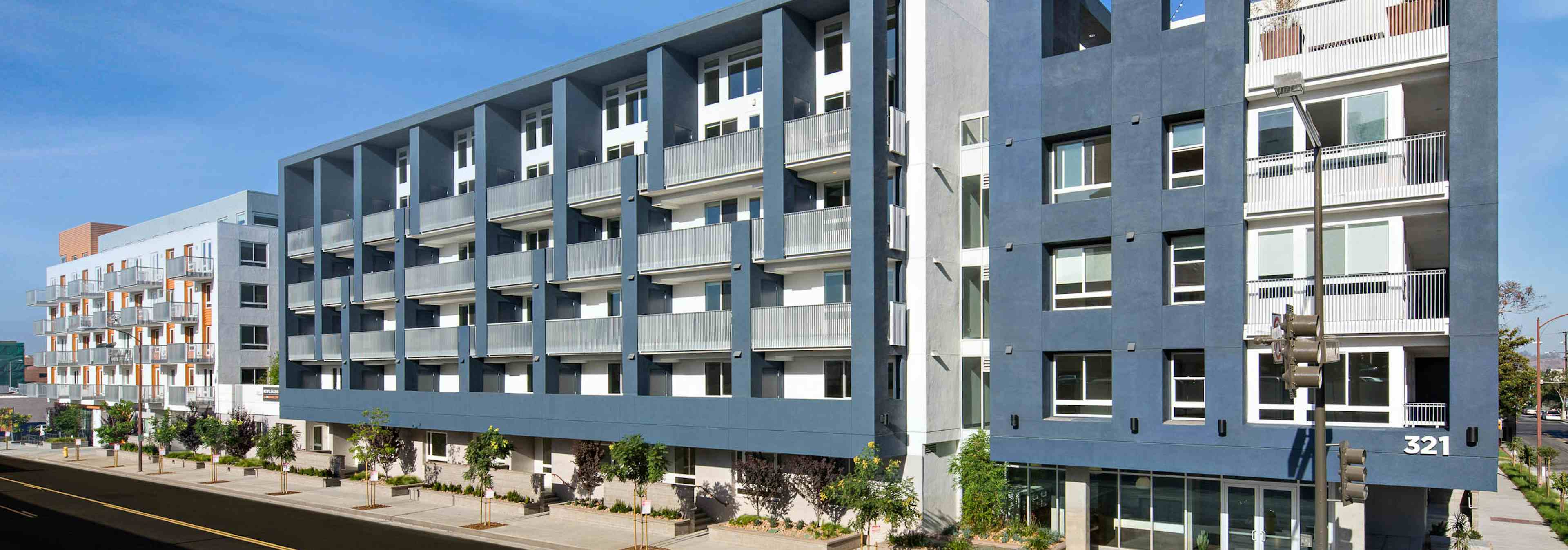 Exterior daytime view of AMLI Lex on Orange apartment building rendering with blue and white facade and surrounded by trees