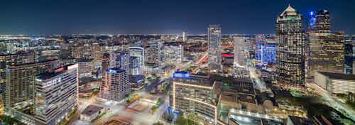 Night view of downtown Dallas skyline with hundreds of colorfully lit up buildings from AMLI Fountain Place apartment building