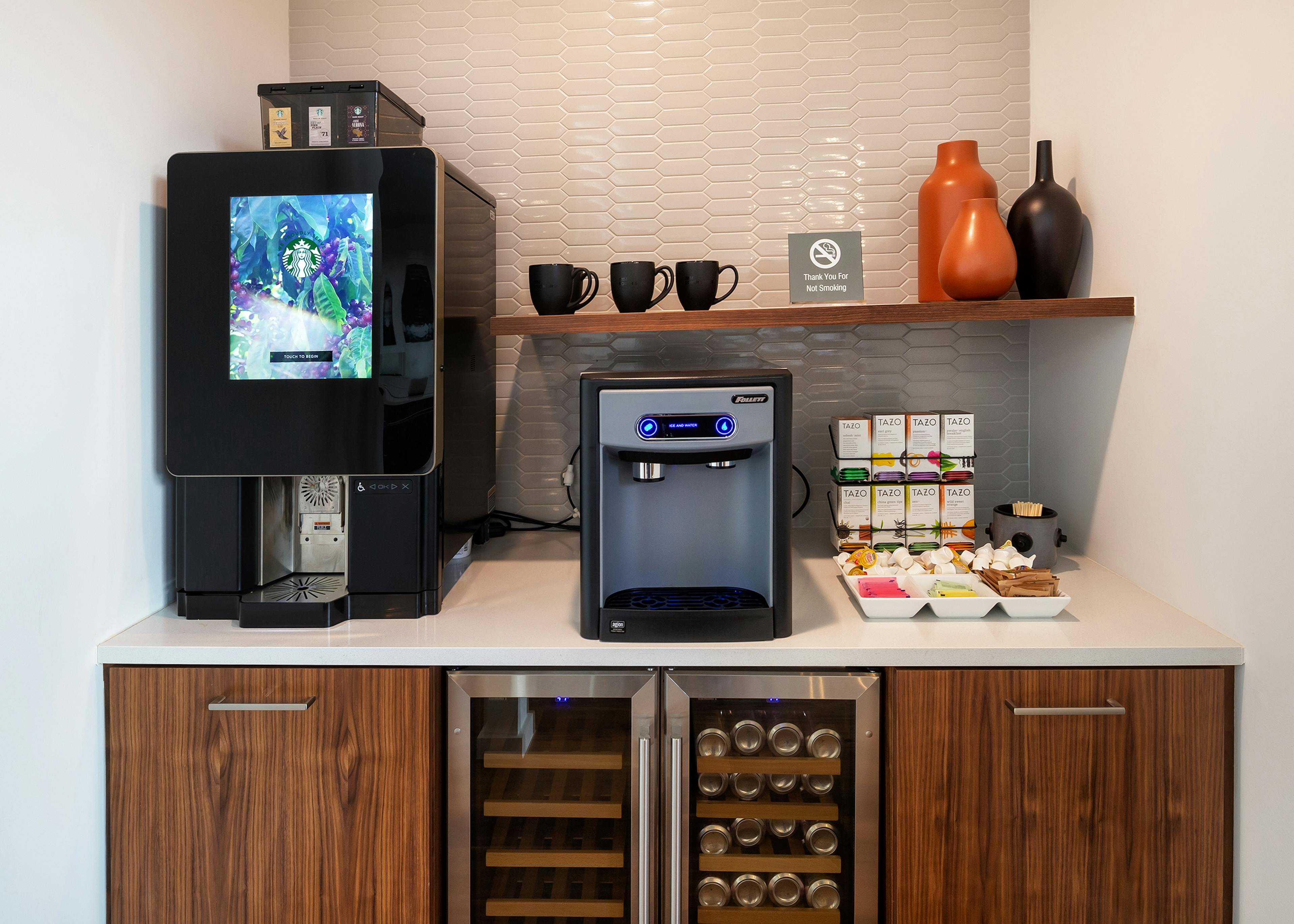 AMLI South Shore java stop with two coffee machines and wood cabinets and a white tile wall in the background and refrigerators at the bottom