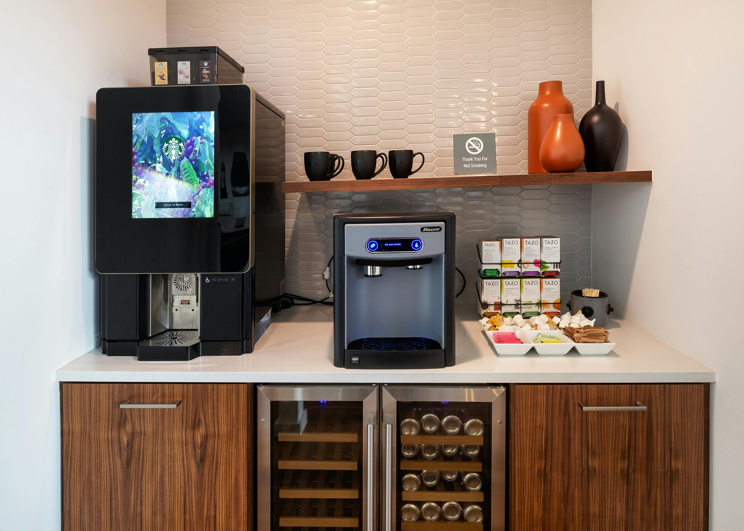 AMLI South Shore java stop with two coffee machines and wood cabinets and a white tile wall in the background and refrigerators at the bottom