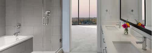 AMLI 3464 bathroom with double vanity sinks across from a glass door which opens up to a standing shower and separate bathtub