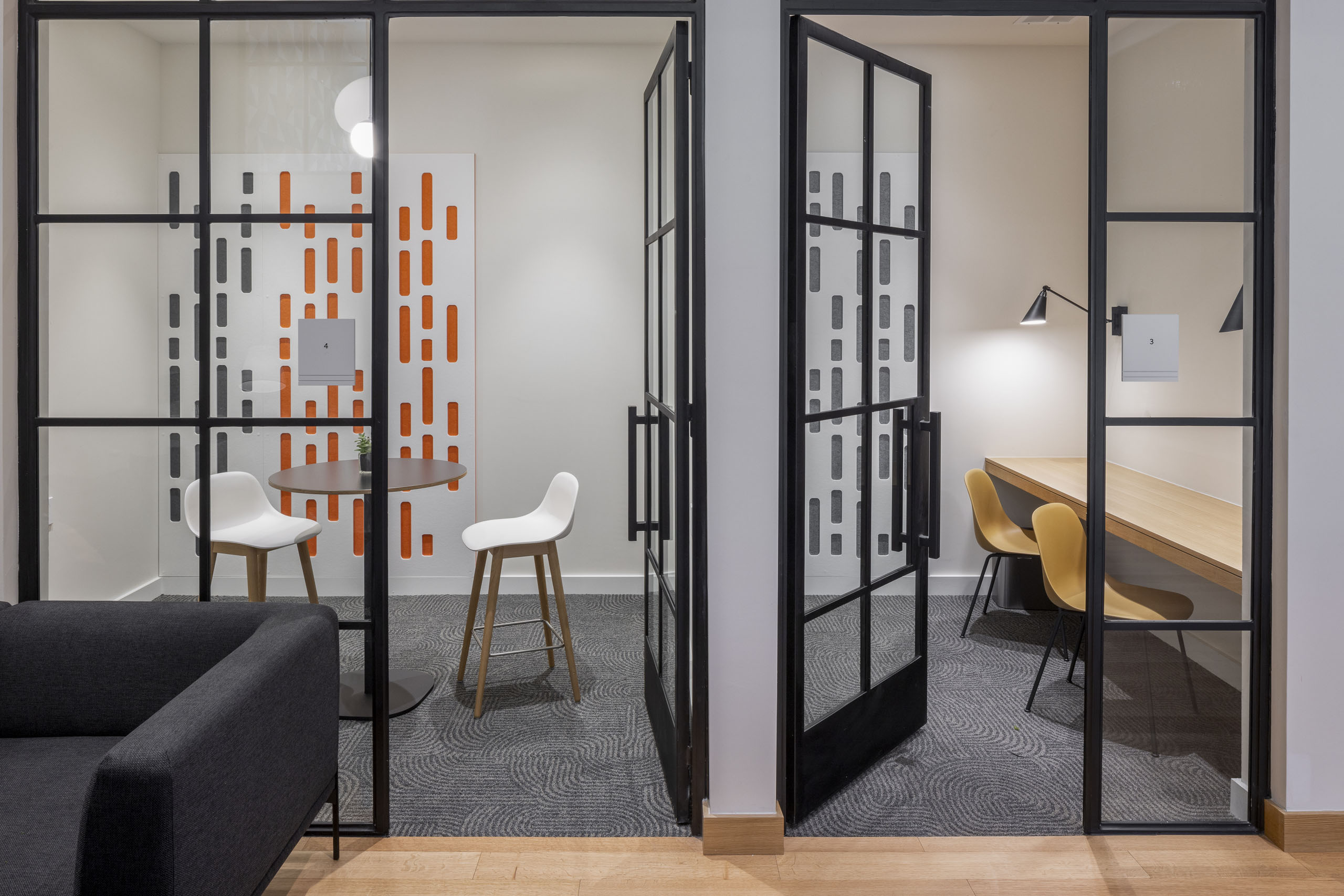 Private working rooms at AMLI Branch Park coworking space with colorful seating and floor to ceiling metal and glass doors