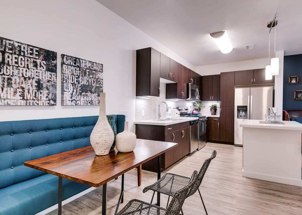 A kitchen and dining room at AMLI Cherry Creek apartments with an island and a dining room table and artwork on the wall