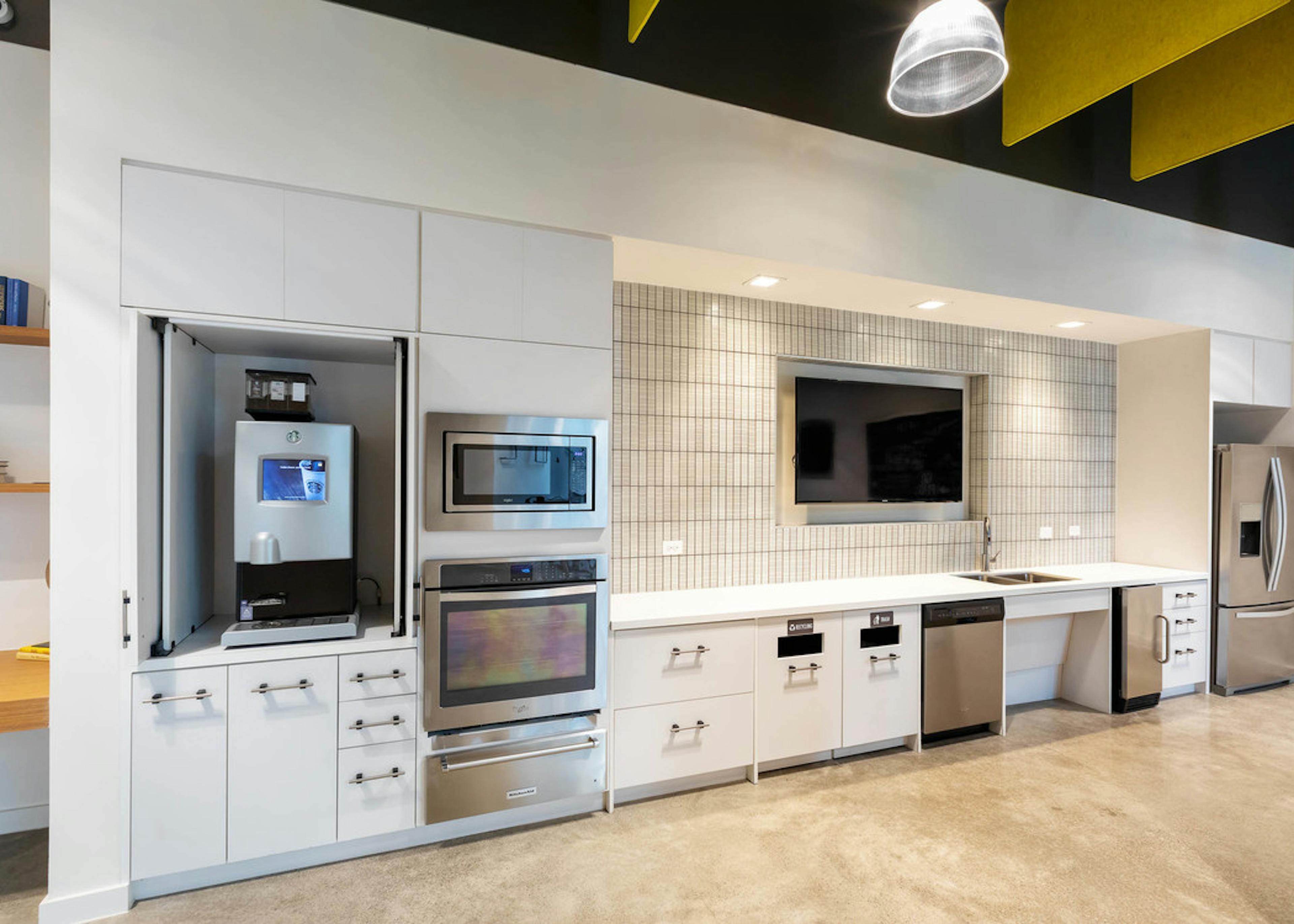 Interior of clubroom java bar and serving kitchen with stainless steel appliances at AMLI Frisco Crossing apartment building