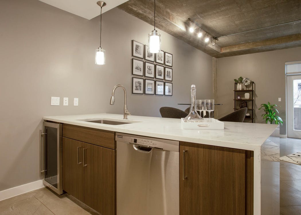 View from behind AMLI Downtown kitchen island with peek into living area with natural light coming in through window