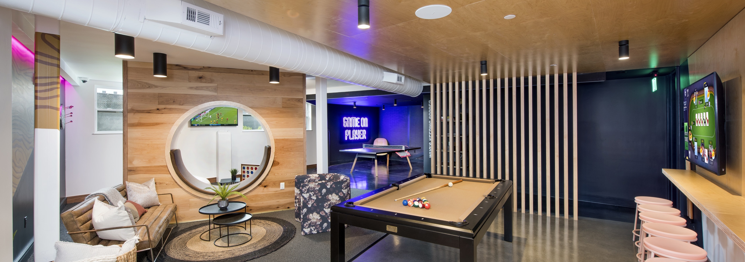 AMLI Lenox game room with pool table and ping pong table and television with multiple seating areas and wooden walls