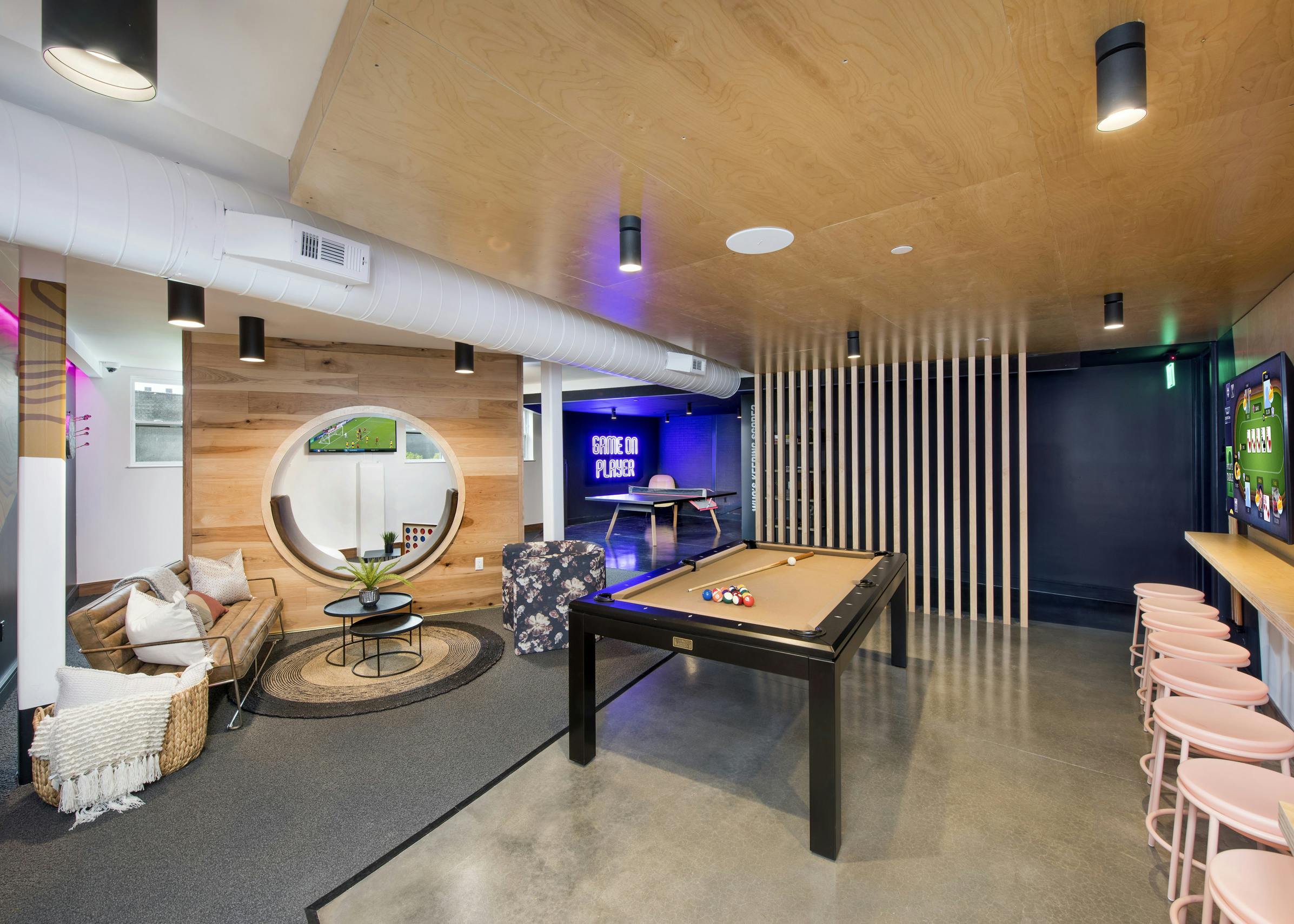 AMLI Lenox game room with pool table and ping pong table and television with multiple seating areas and wooden walls
