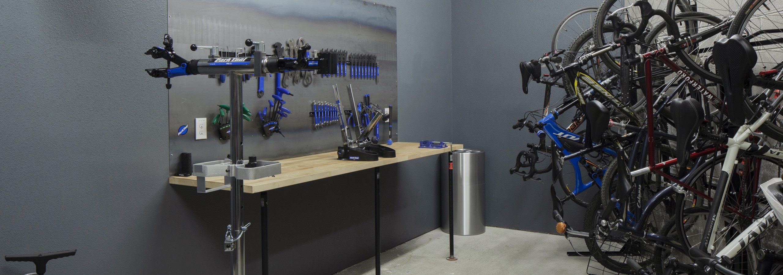 Interior bike repair room area at AMLI Riverfront Green apartments with view of work station table with tools and bike racks