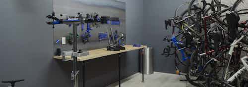 Interior bike repair room area at AMLI Riverfront Green apartments with view of work station table with tools and bike racks