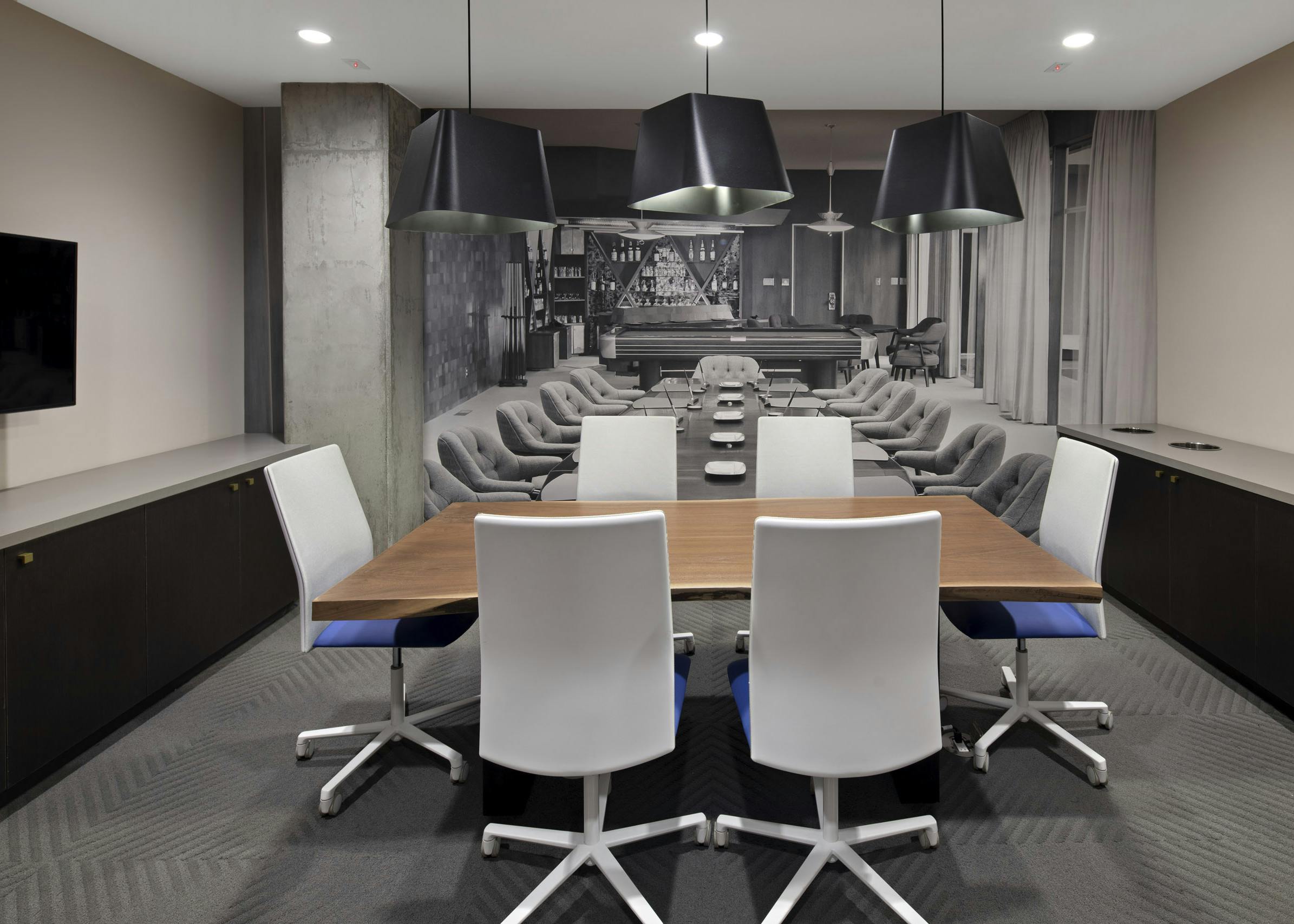 Interior view of conference room at AMLI Park Broadway apartments with table and six chairs and designer wallpaper and big screen TV