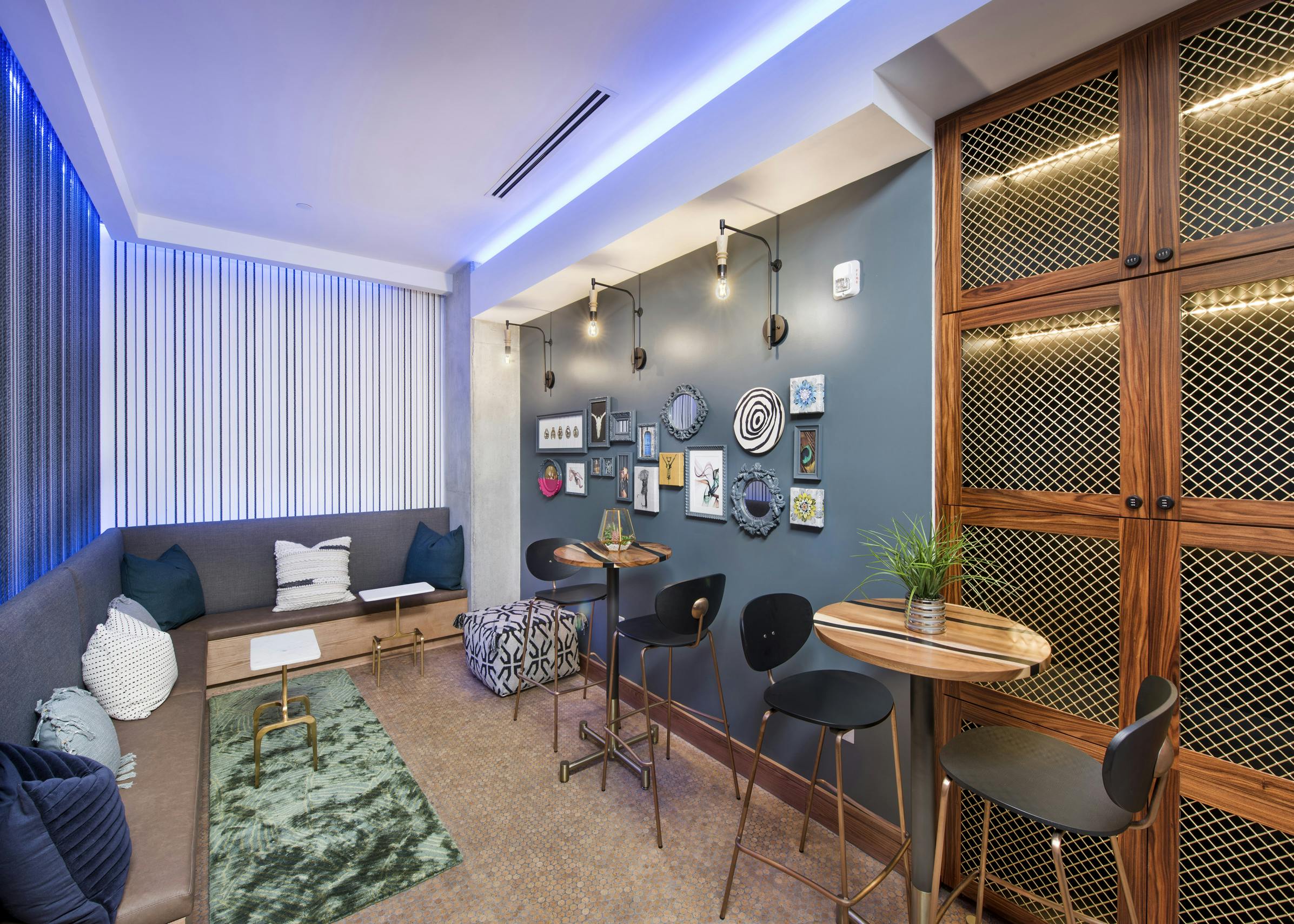 Interior of wine room at AMLI Lenox with wrap around sofa and two tables and chairs with and wine lockers to store wine