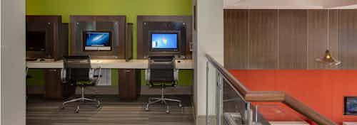 Interior of the business center at AMLI Ponce Park with multiple computers and a printer with leather rolling chairs