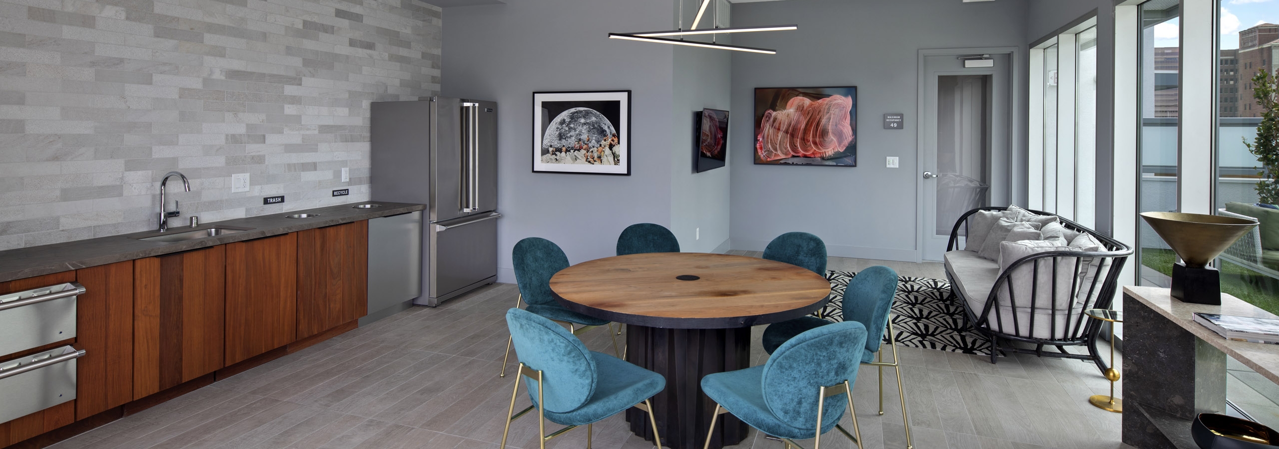 Interior view of AMLI Park Broadway rooftop lounge with catering kitchen and a variety of seating and flat screen TV