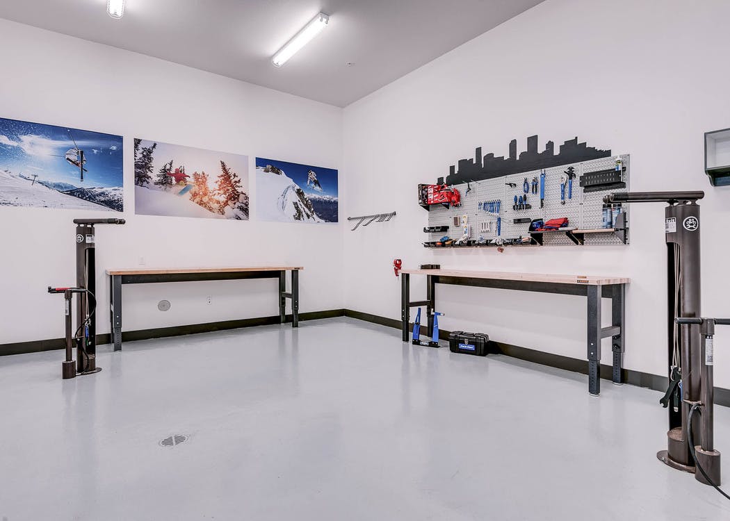 Interior bike repair room area at AMLI Cherry Creek apartments with view of work station table with tools and photography