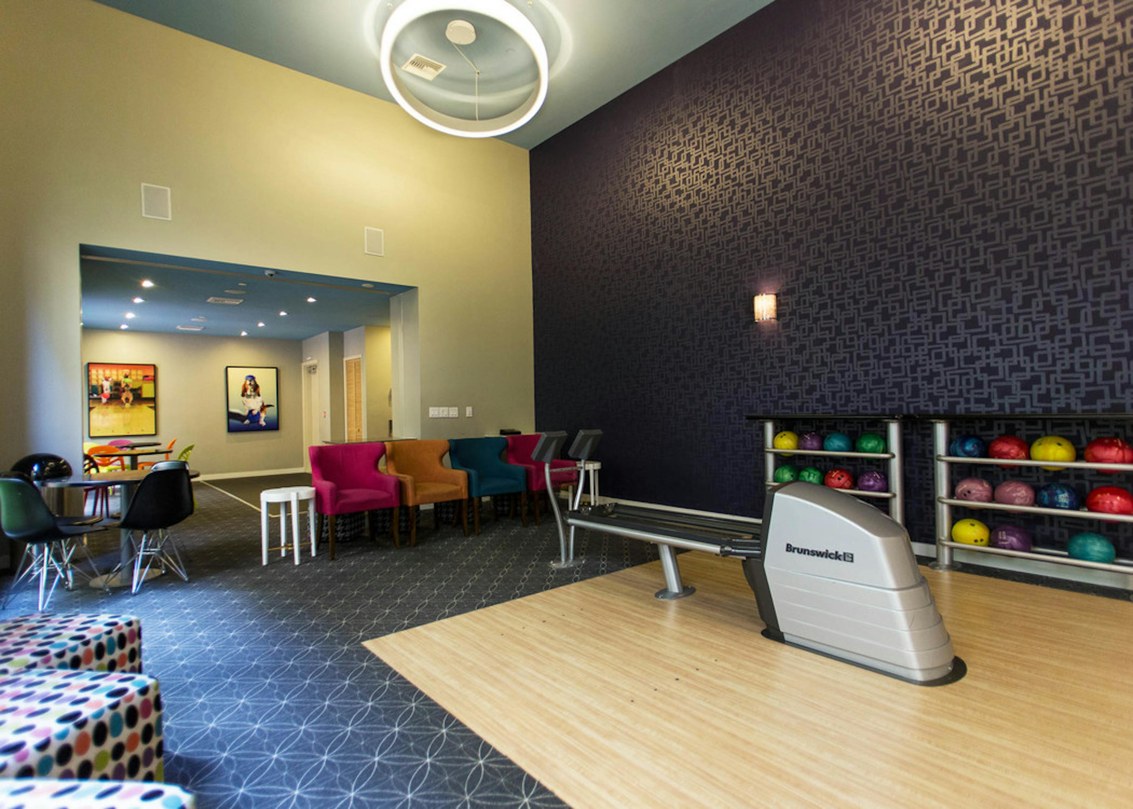 Interior of the two lane bowling alley at AMLI Dadeland apartment’s equipped with colorful bowling balls and tv screen