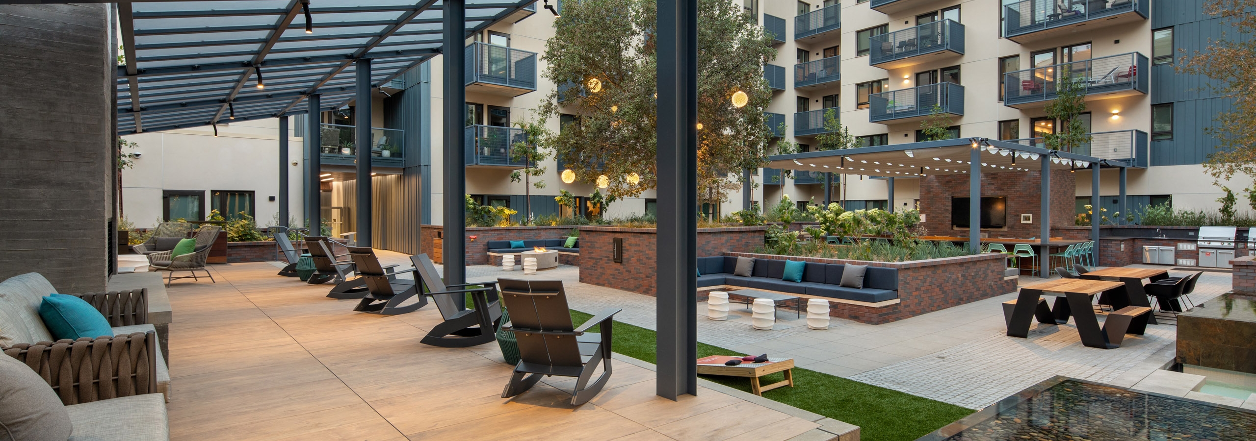 View of expansive courtyard with an elevated hardwood flooring platform and various lounge seating at AMLI Old Pasadena