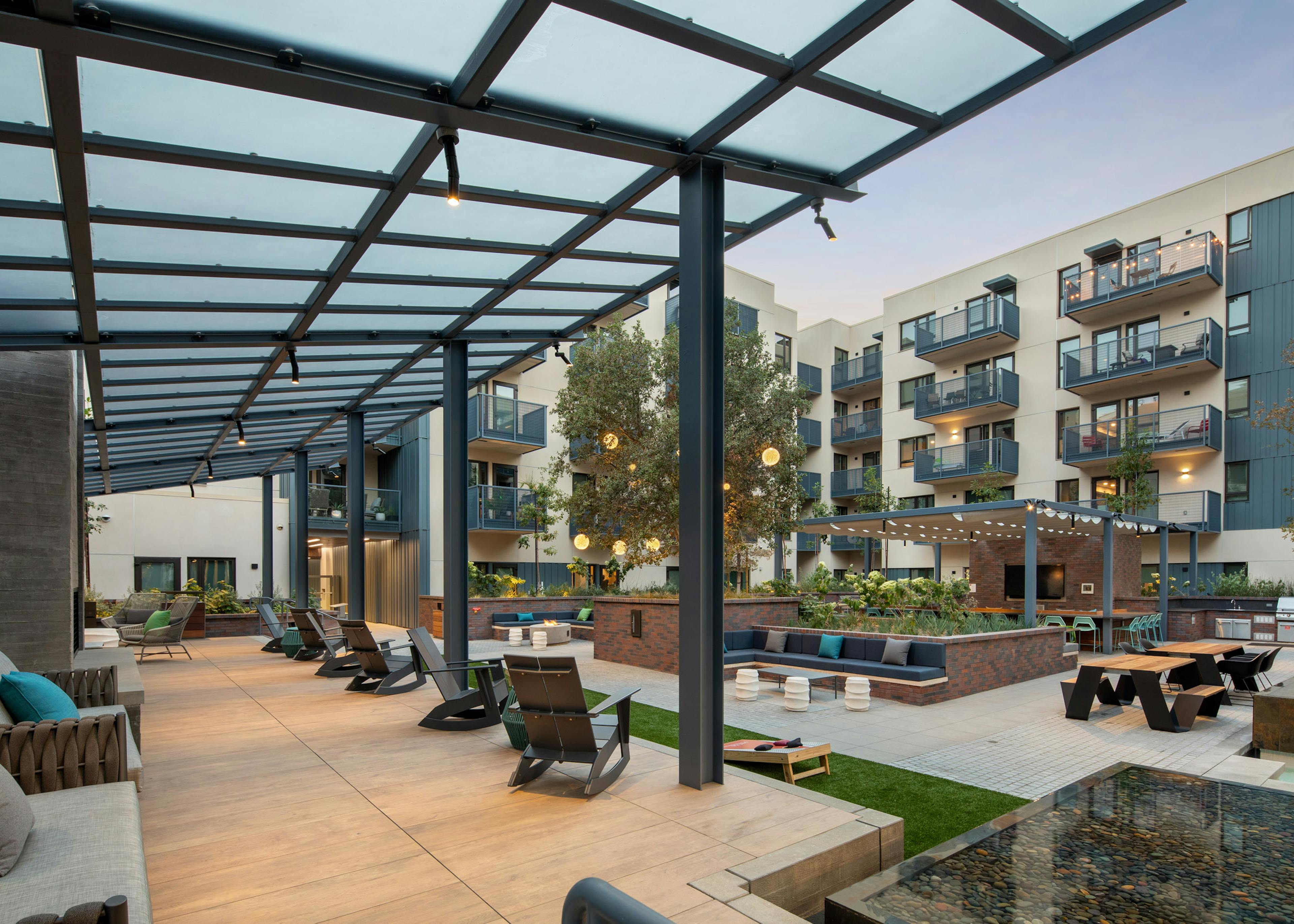 View of expansive courtyard with an elevated hardwood flooring platform and various lounge seating at AMLI Old Pasadena 