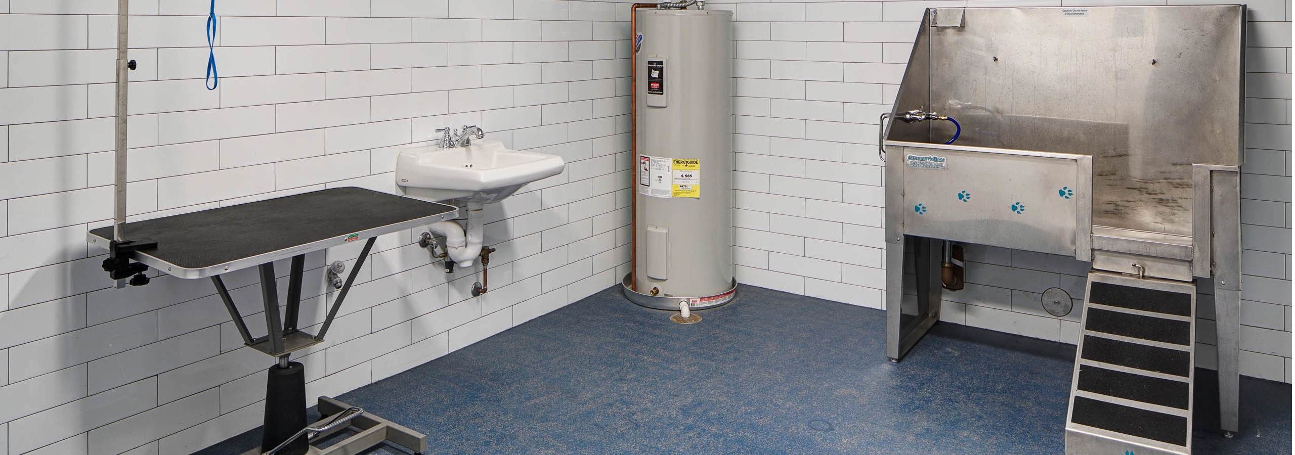 Interior view of paw wash amenity at AMLI Deerfield equipped with pet bath and grooming table and a hand wash sink