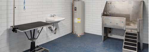 Interior view of paw wash amenity at AMLI Deerfield equipped with pet bath and grooming table and a hand wash sink