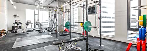 Interior Fitness Center of AMLI Arc with free standing weights squat racks with colorful weights and cardio equipment
