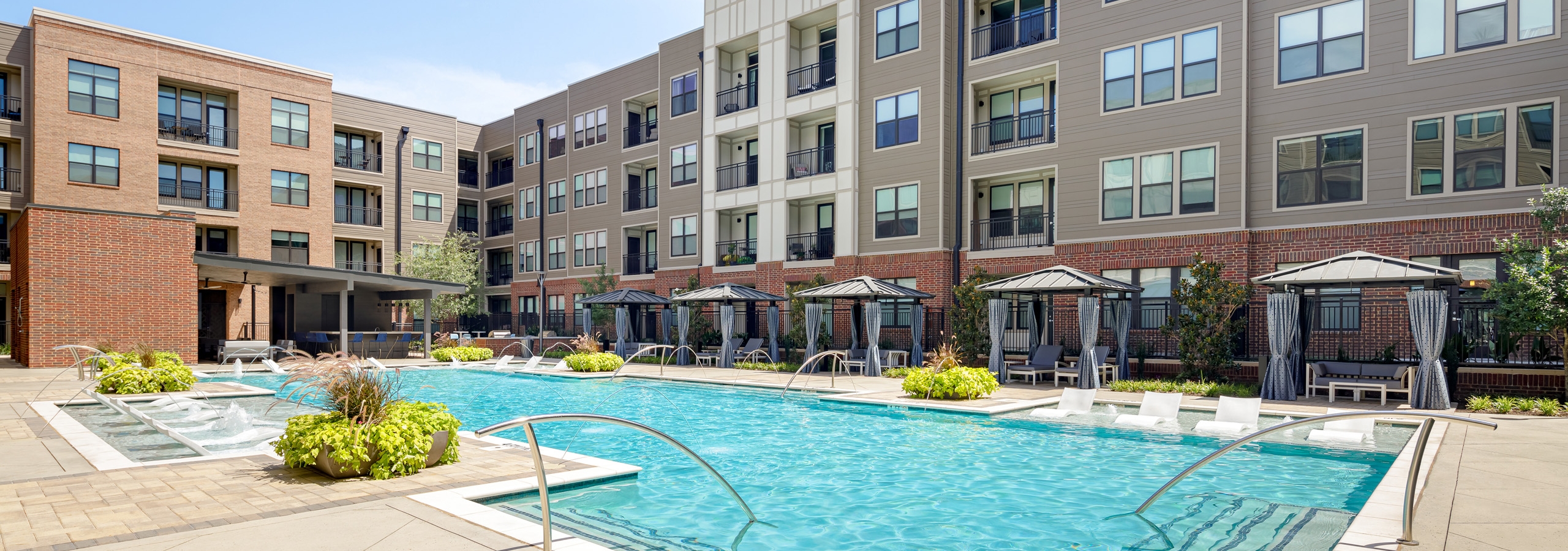 AMLI Addison apartment building pool with private cabanas and outdoor entertainment area and lounge seating and lush planters