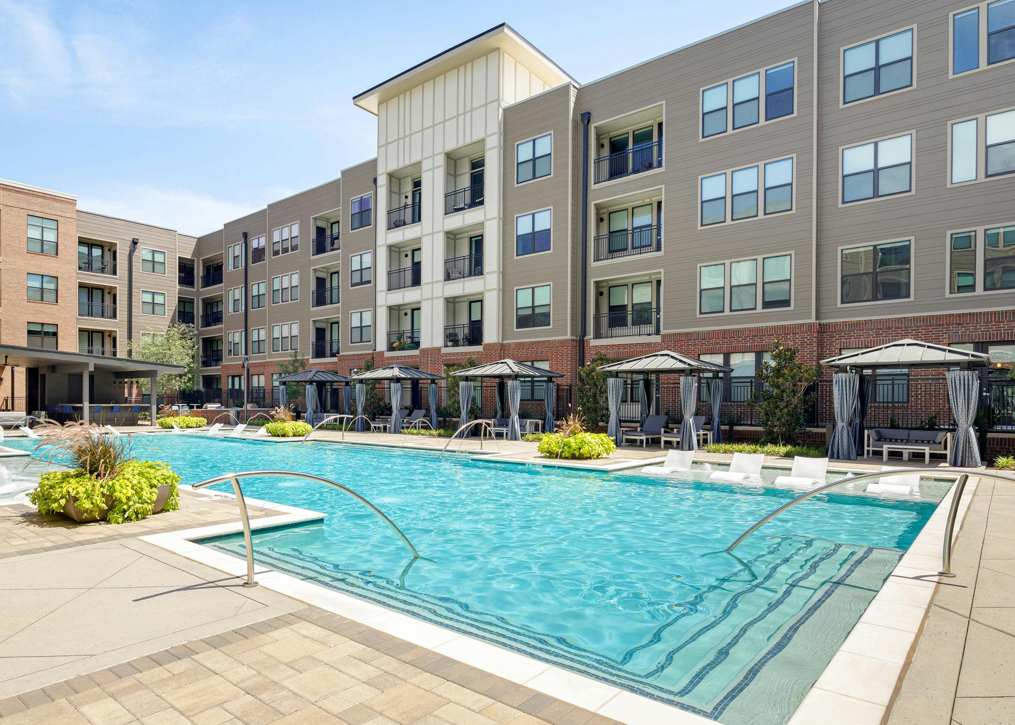 AMLI Addison apartment building pool with private cabanas and outdoor entertainment area and lounge seating and lush planters