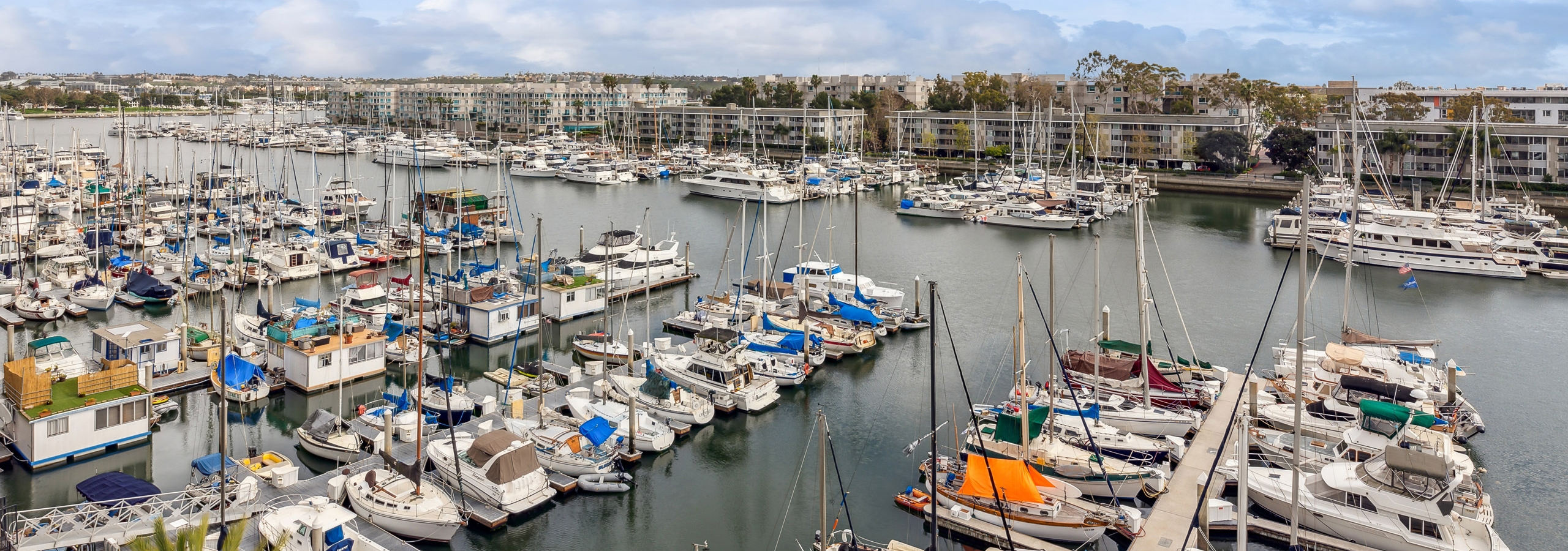 View from a balcony of marina with many many boats docked with buildings in the distance  at AMLI Marina Del Rey