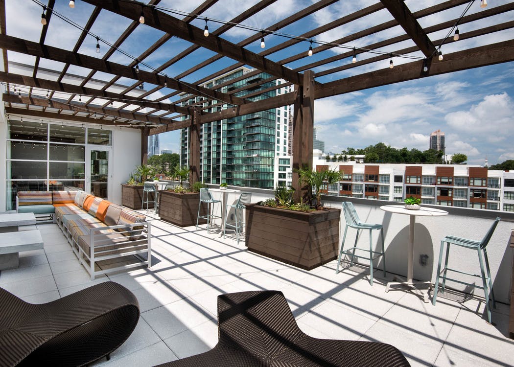 AMLI Buckhead apartment building skydeck with a bright daytime view showing long outdoor seating under a pergola