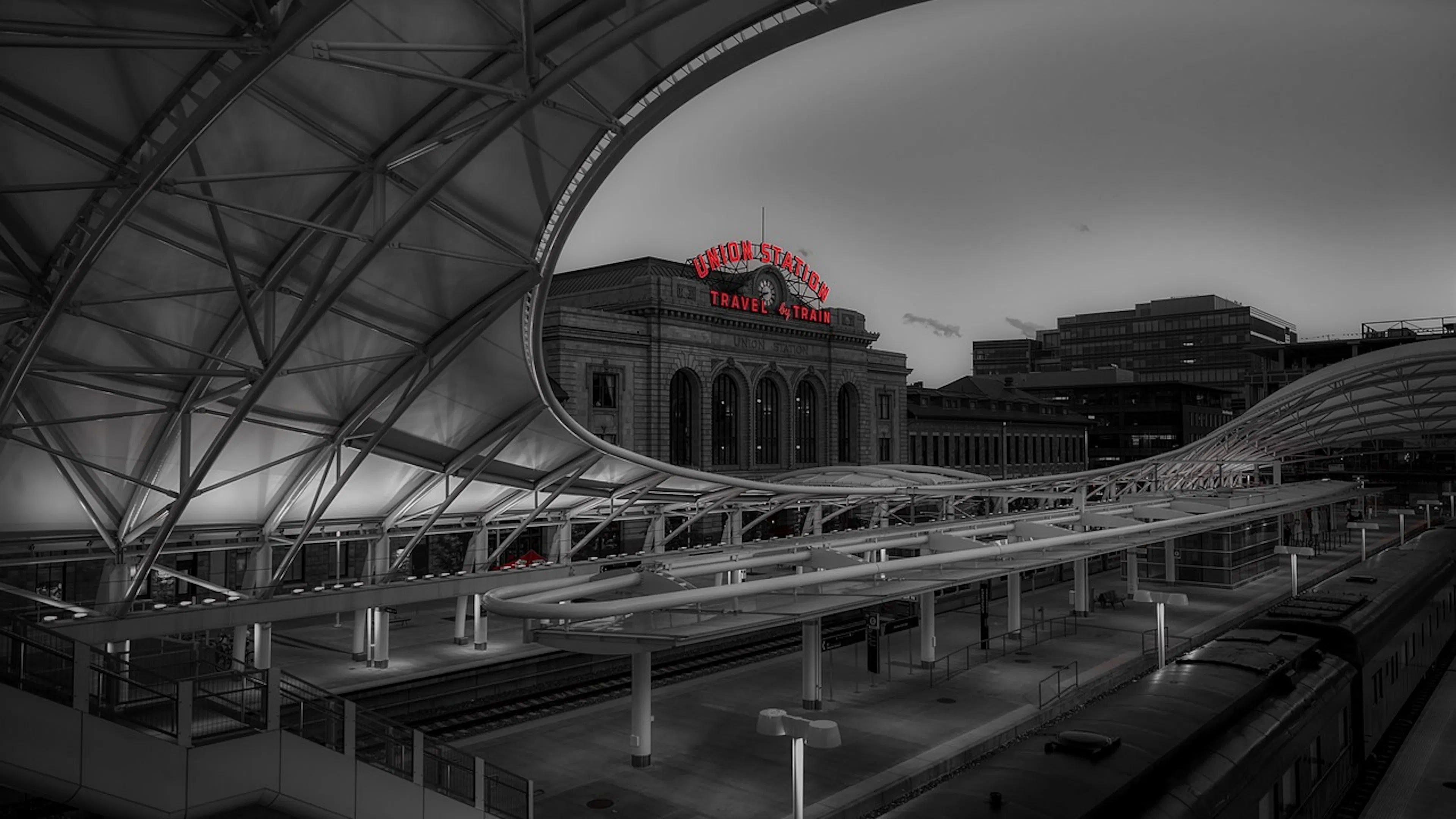 A dark black and white image of Denver's Union Station sign taken from inside a nearby warehouse