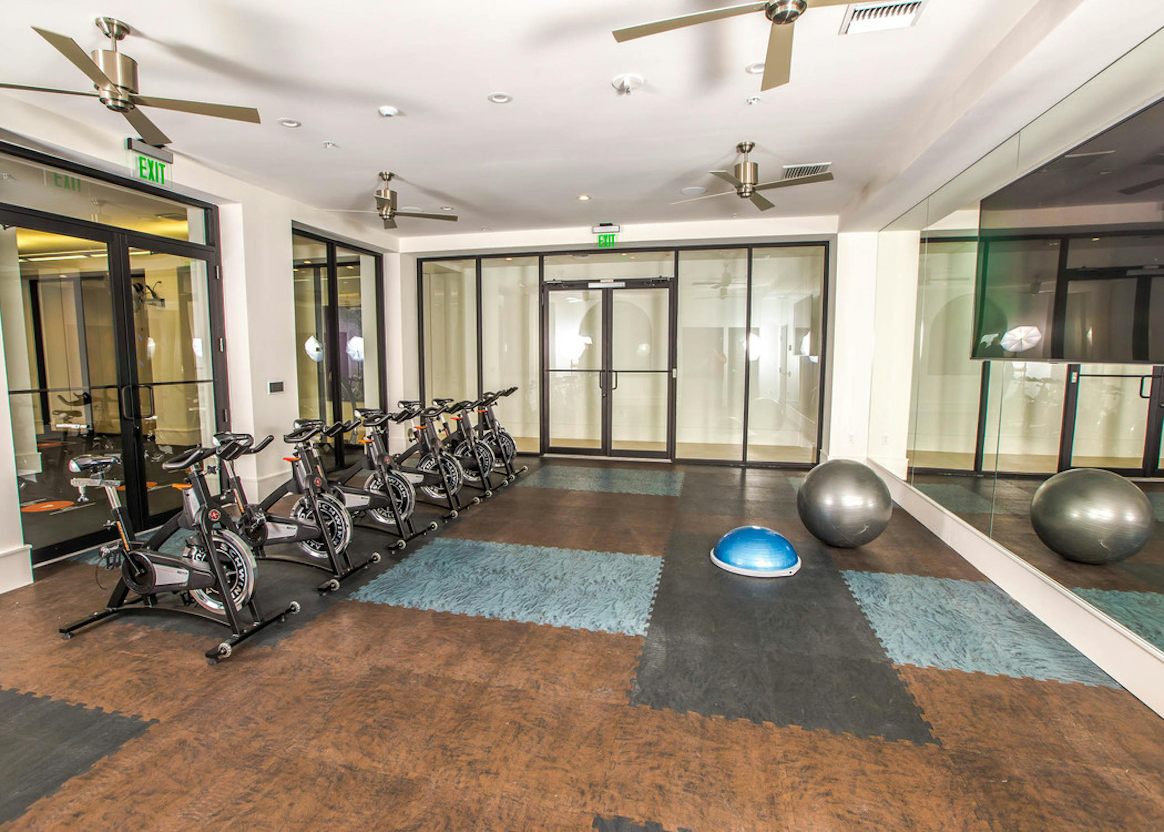Interior of spinning room at AMLI Joya with multiple spin bikes and full mirrored wall 