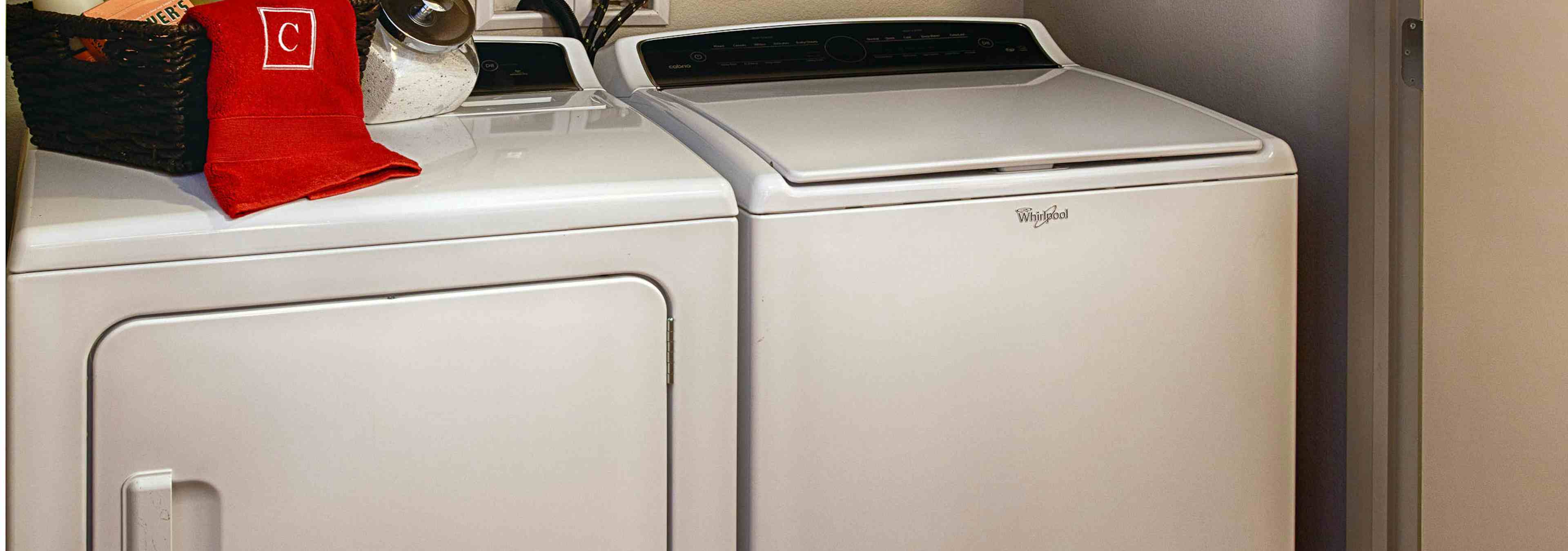 A laundry area at AMLI Denargo Market apartments with a white washer and dryer side by side with a view of the closet door