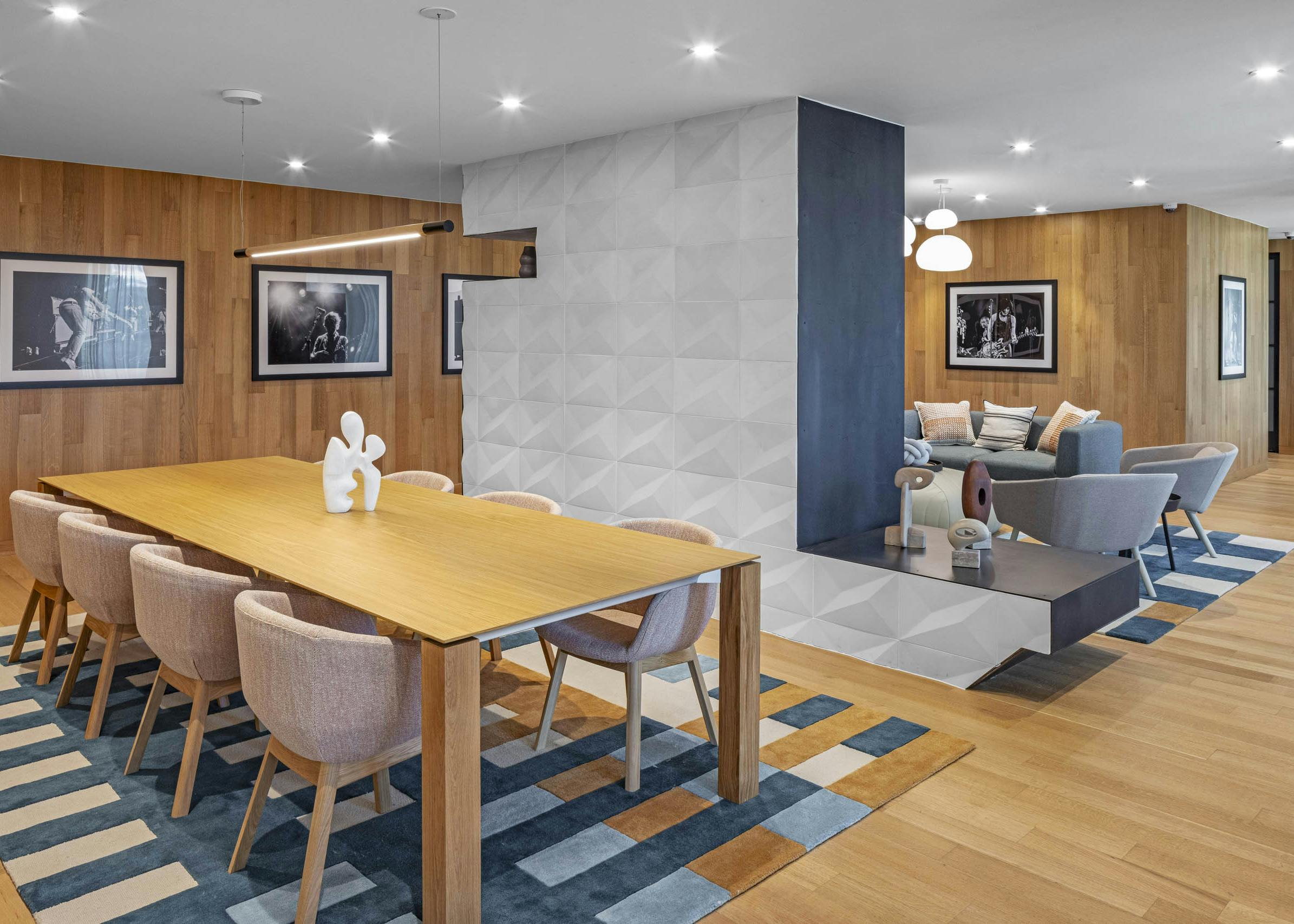 AMLI Branch Park lounge with wood plank walls and conference table with chairs and dividing wall with seating area