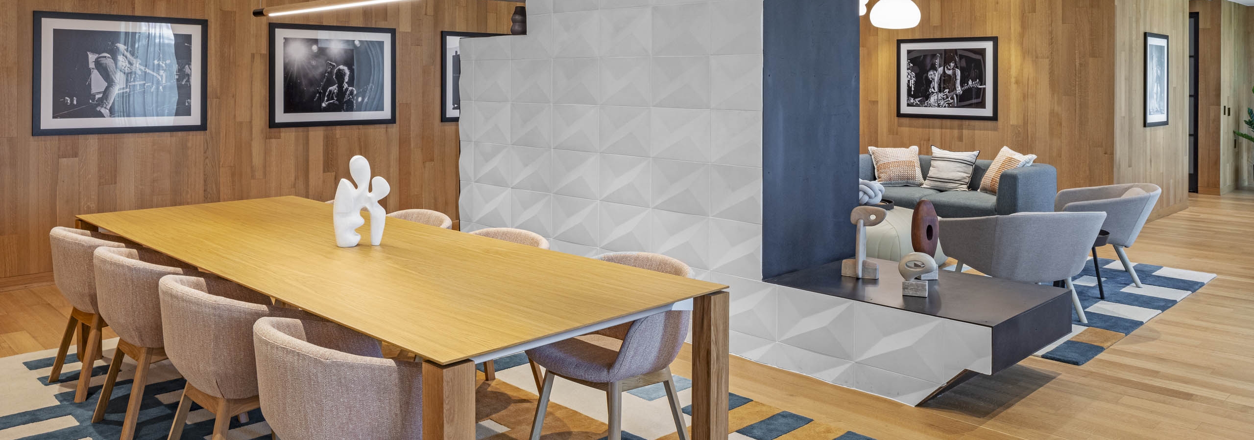 AMLI Branch Park lounge with wood plank walls and conference table with chairs and dividing wall with seating area