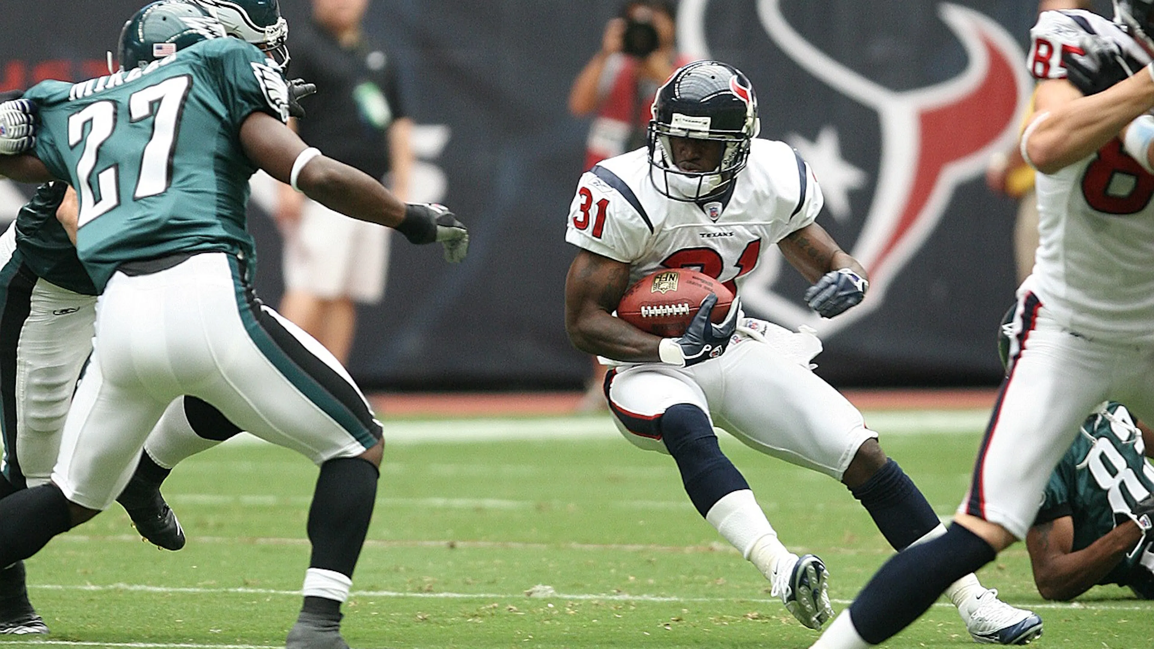 A Houston Texans running back evading Philadelphia Eagles defenders during an NFL game