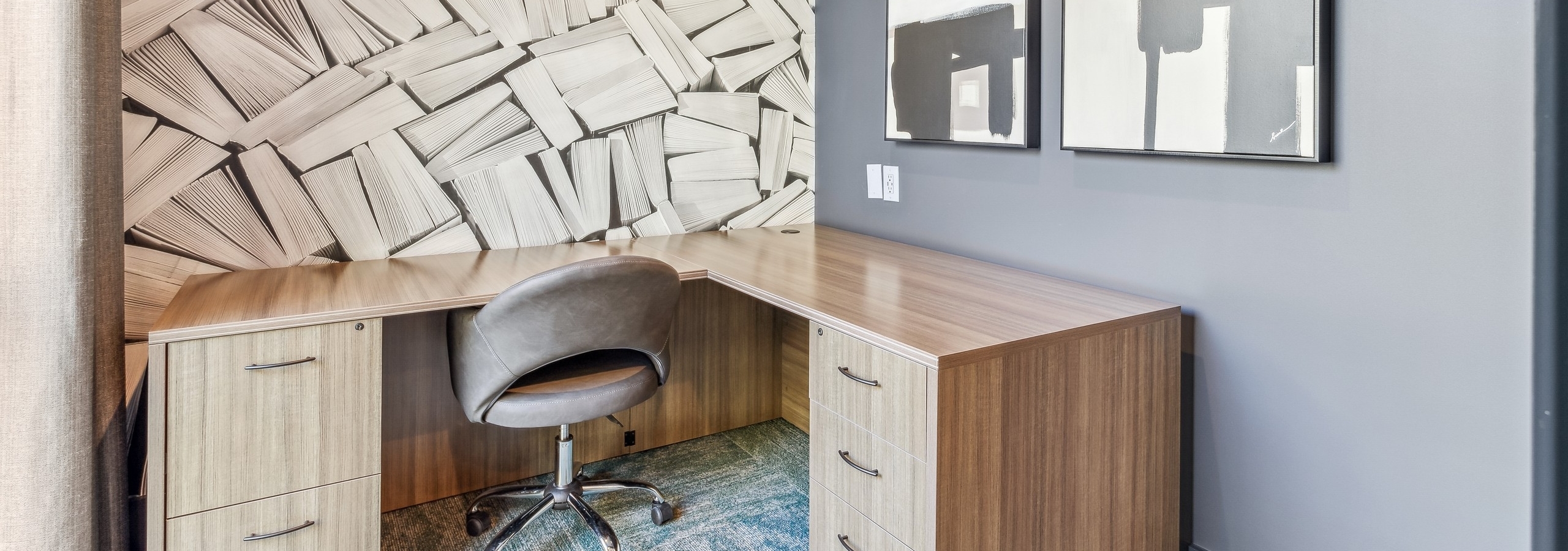 AMLI Parkside private office with wood grain l-shaped desk and brown chair and geometric black and white wallpaper