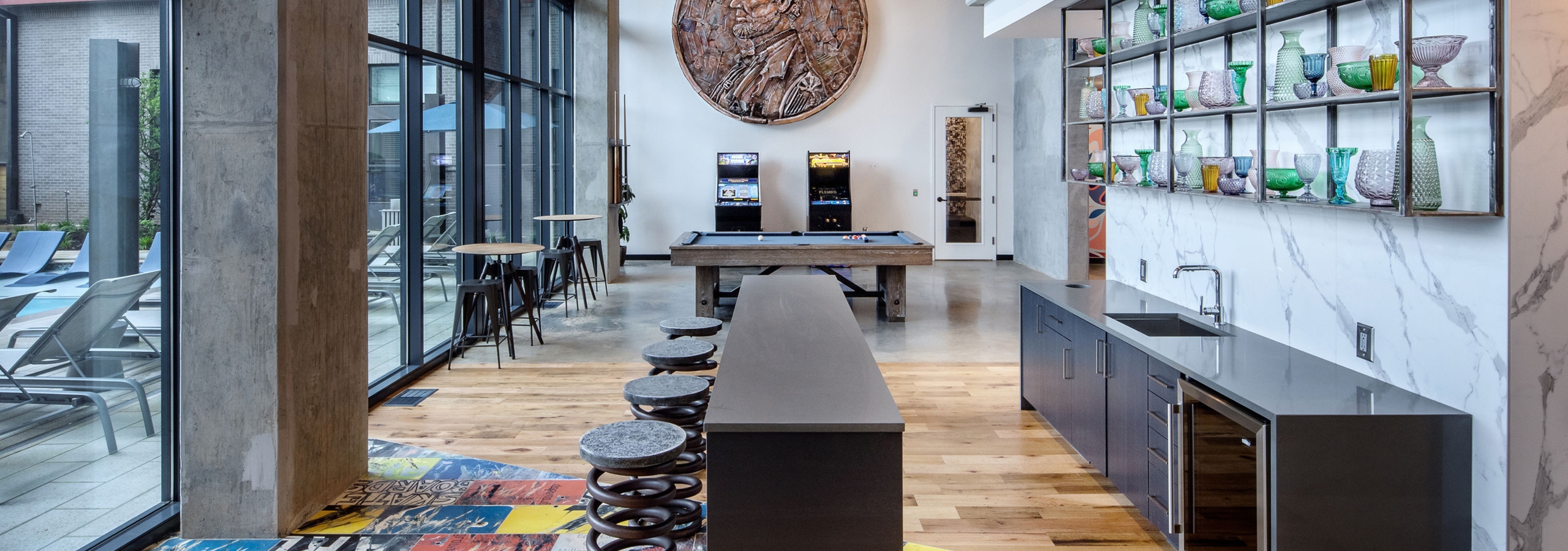 AMLI Westside apartment clubroom with kitchen and lounge area as well as billiards and games with penny artwork on wall