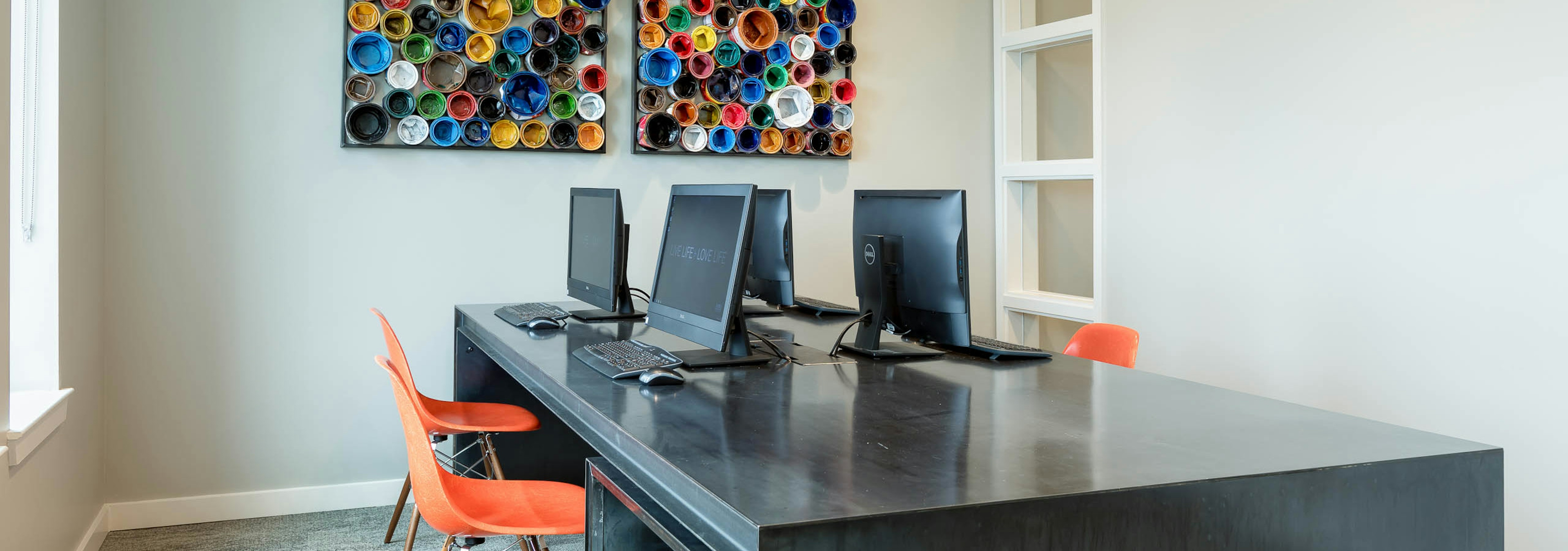 Interior view of business center at AMLI Frisco Crossing apartment building with four computer stations and chairs