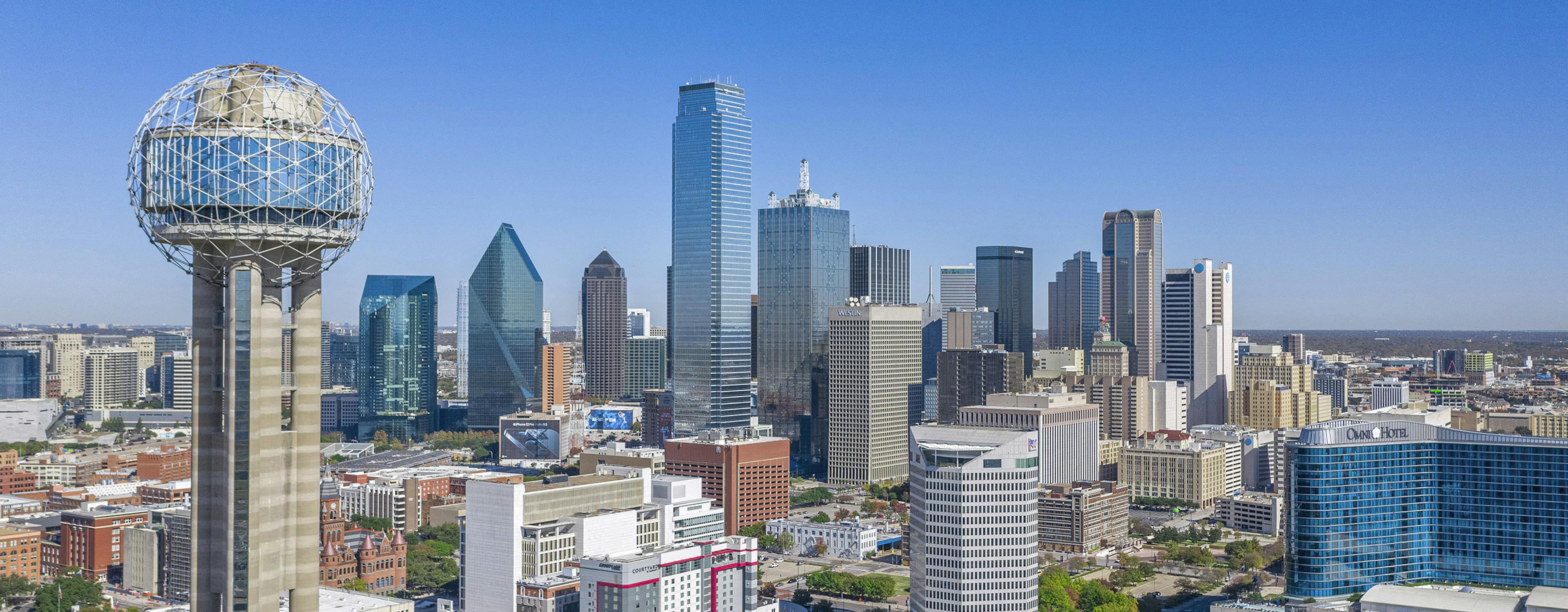 Aerial day view of downtown Dallas with the Reunion Tower in front and skyscrapers and AMLI Fountain Place in the background