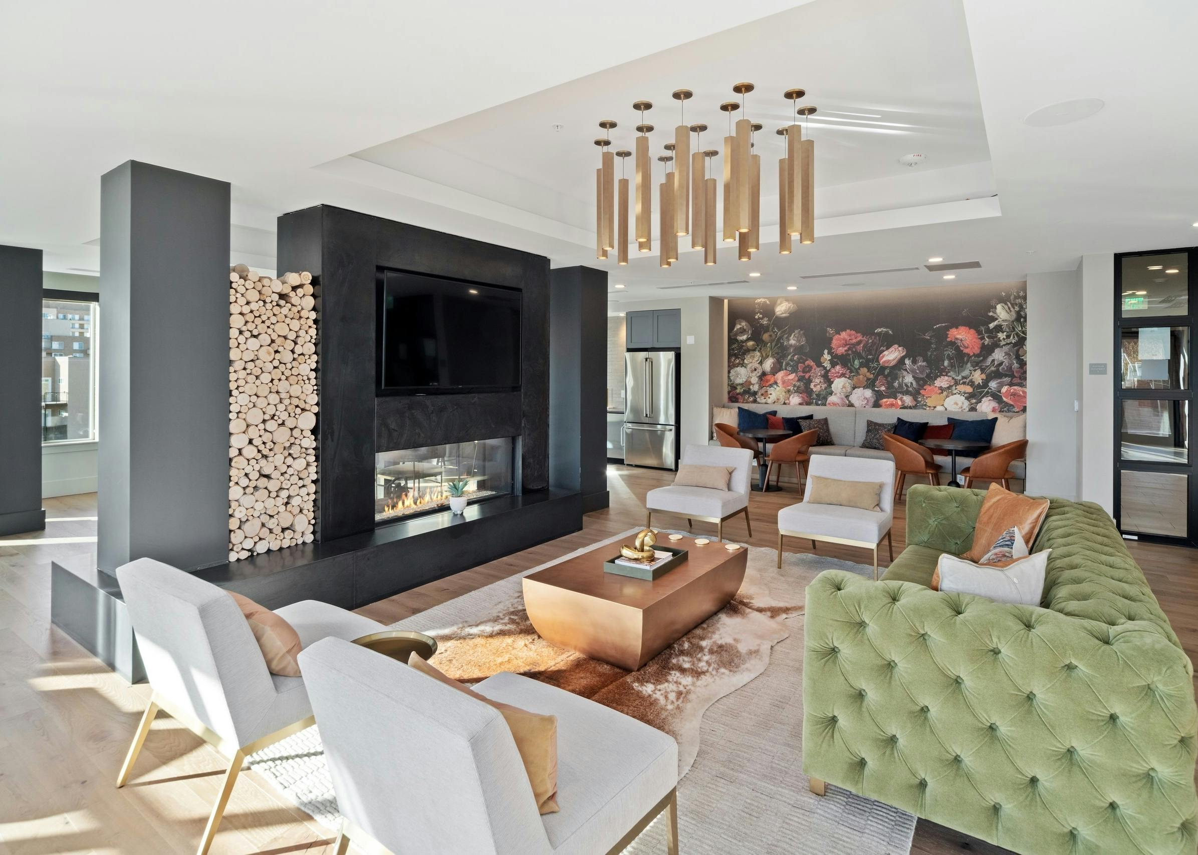 AMLI at Uptown resident lounge with vintage style furniture placed around a modern fireplace with mounted flat screen TV