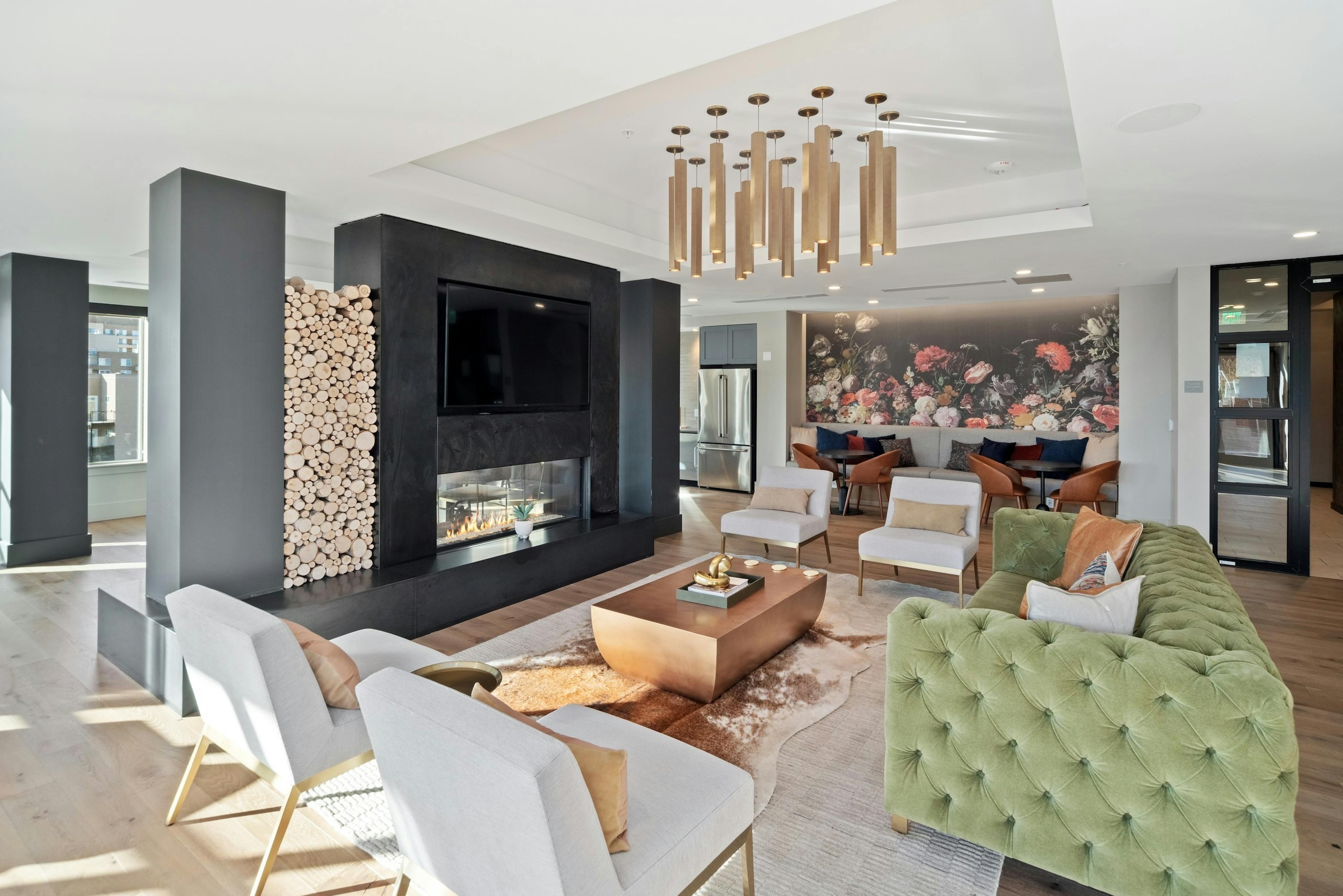 AMLI at Uptown resident lounge with vintage style furniture placed around a modern fireplace with mounted flat screen TV 
