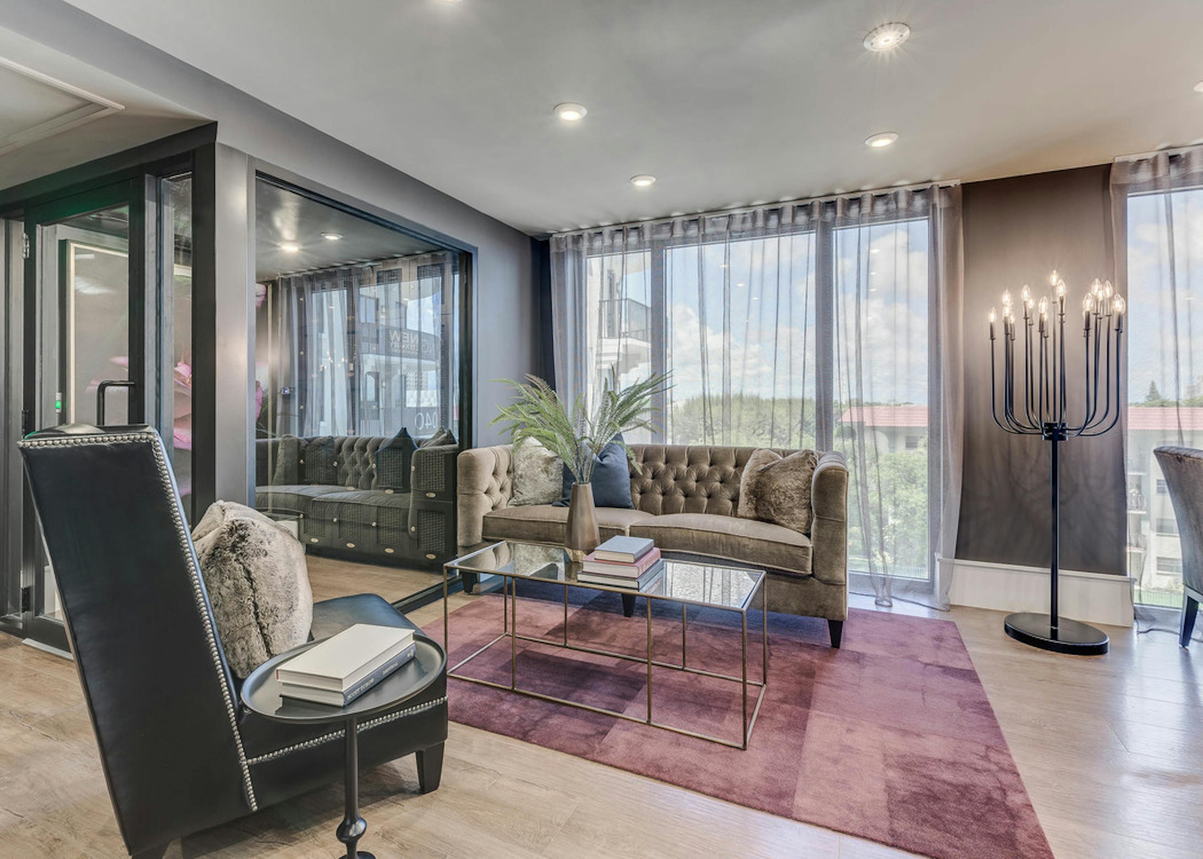 Second floor interior view of the AMLI Joya two story resident lounge with modern furnishings and floor to ceiling windows 