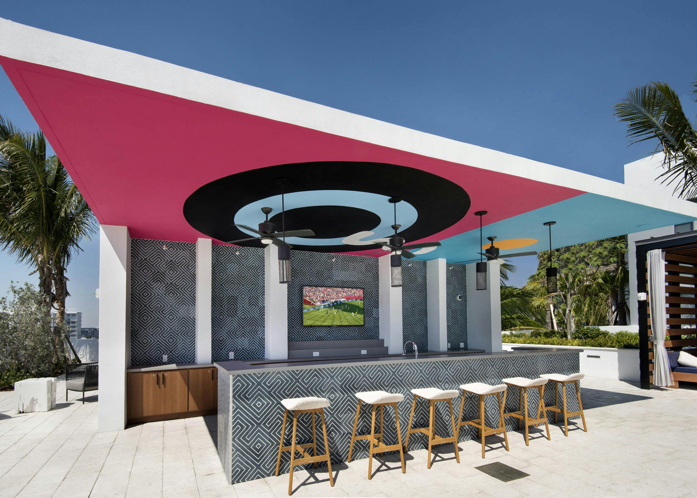 Pool bar with ceiling depicting bullseye painting at AMLI Midtown 29 apartments with navy and white tile bar and wood stools