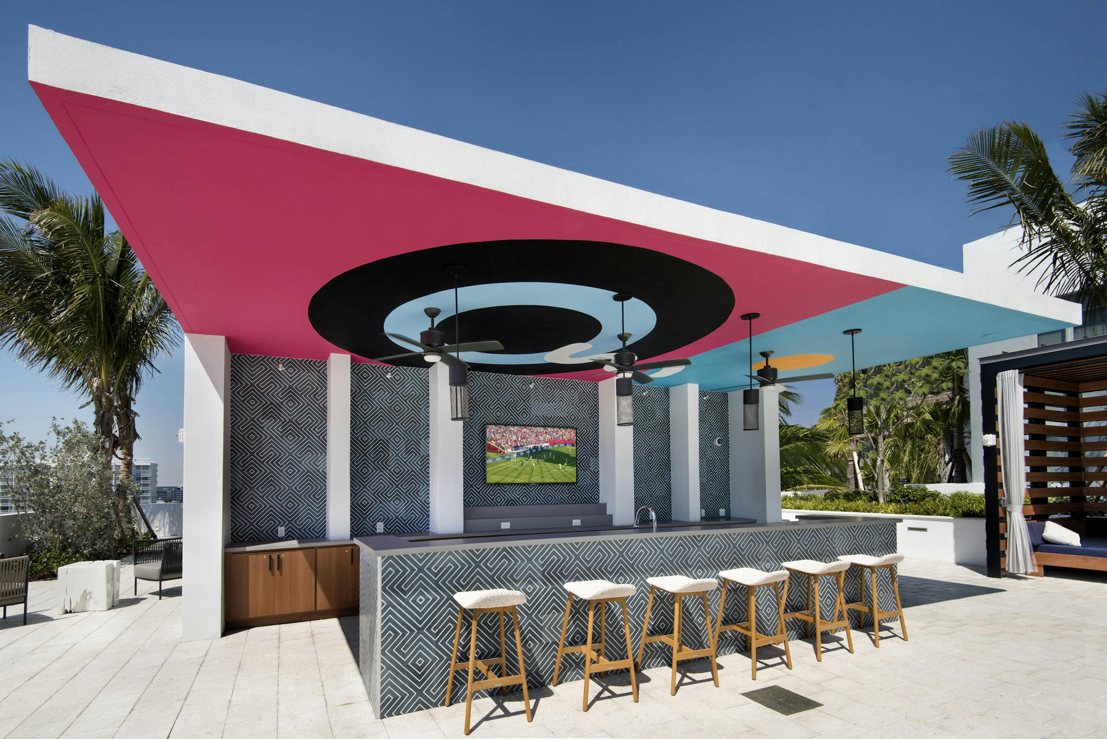 Pool bar with ceiling depicting bullseye painting at AMLI Midtown 29 apartments with navy and white tile bar and wood stools