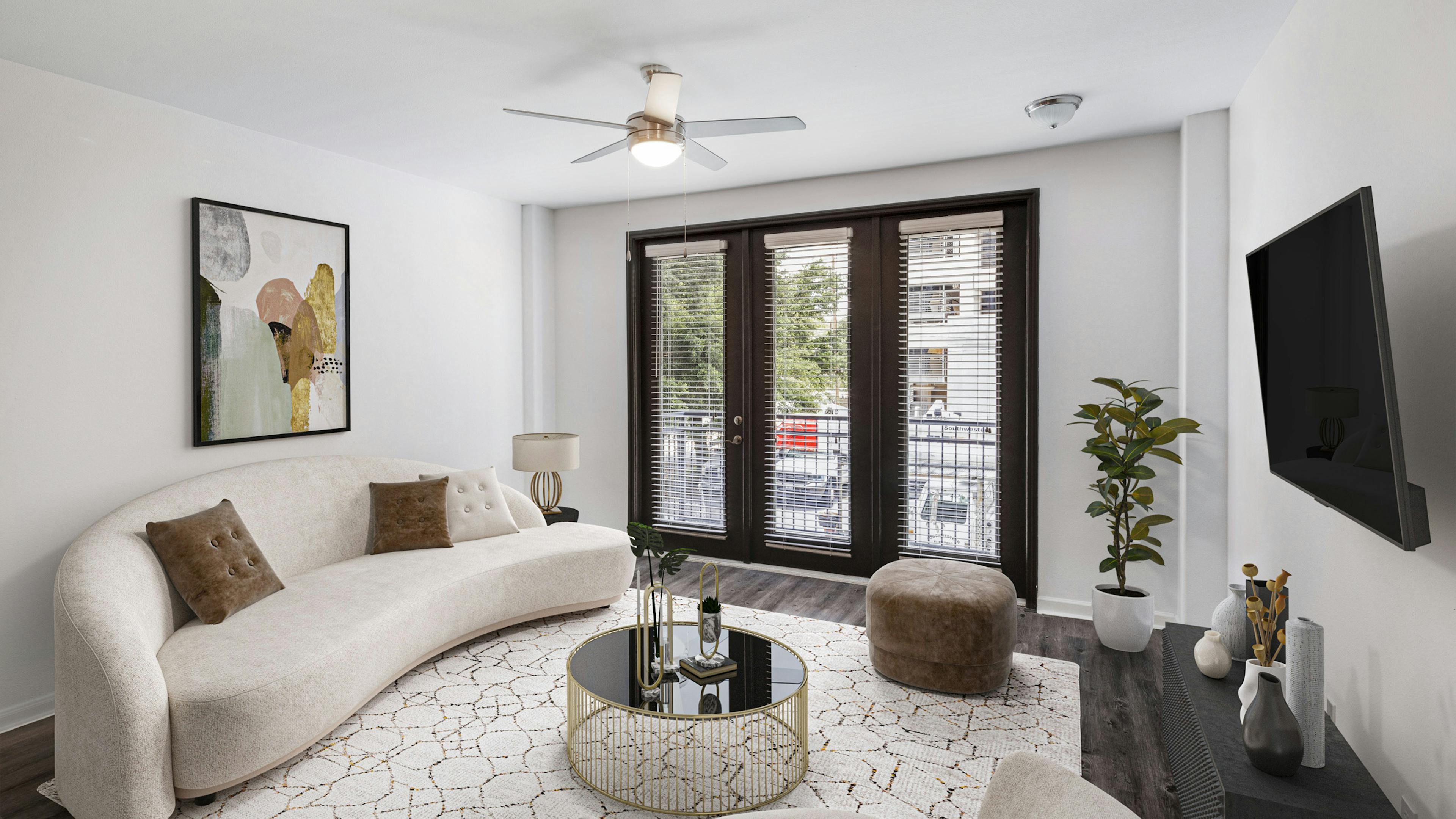 Interior view of AMLI 300 apartment living room with modern white couch with colorful artwork above and door to a balcony