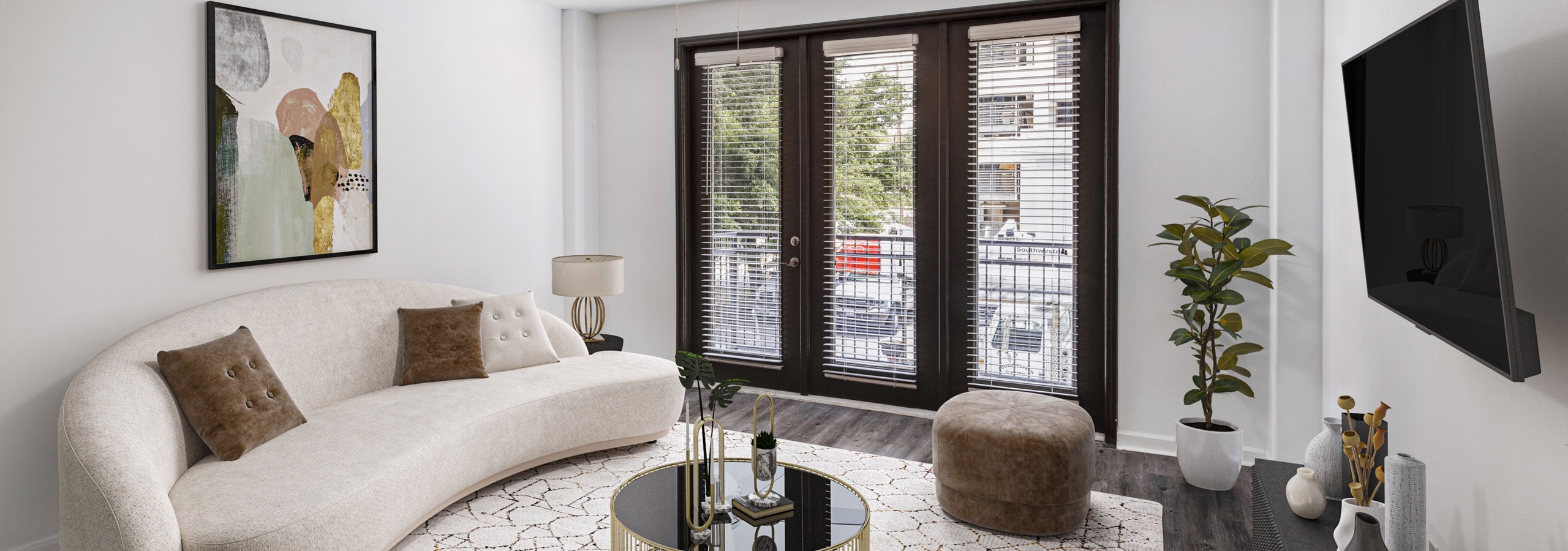Interior view of AMLI 300 apartment living room with modern white couch with colorful artwork above and door to a balcony