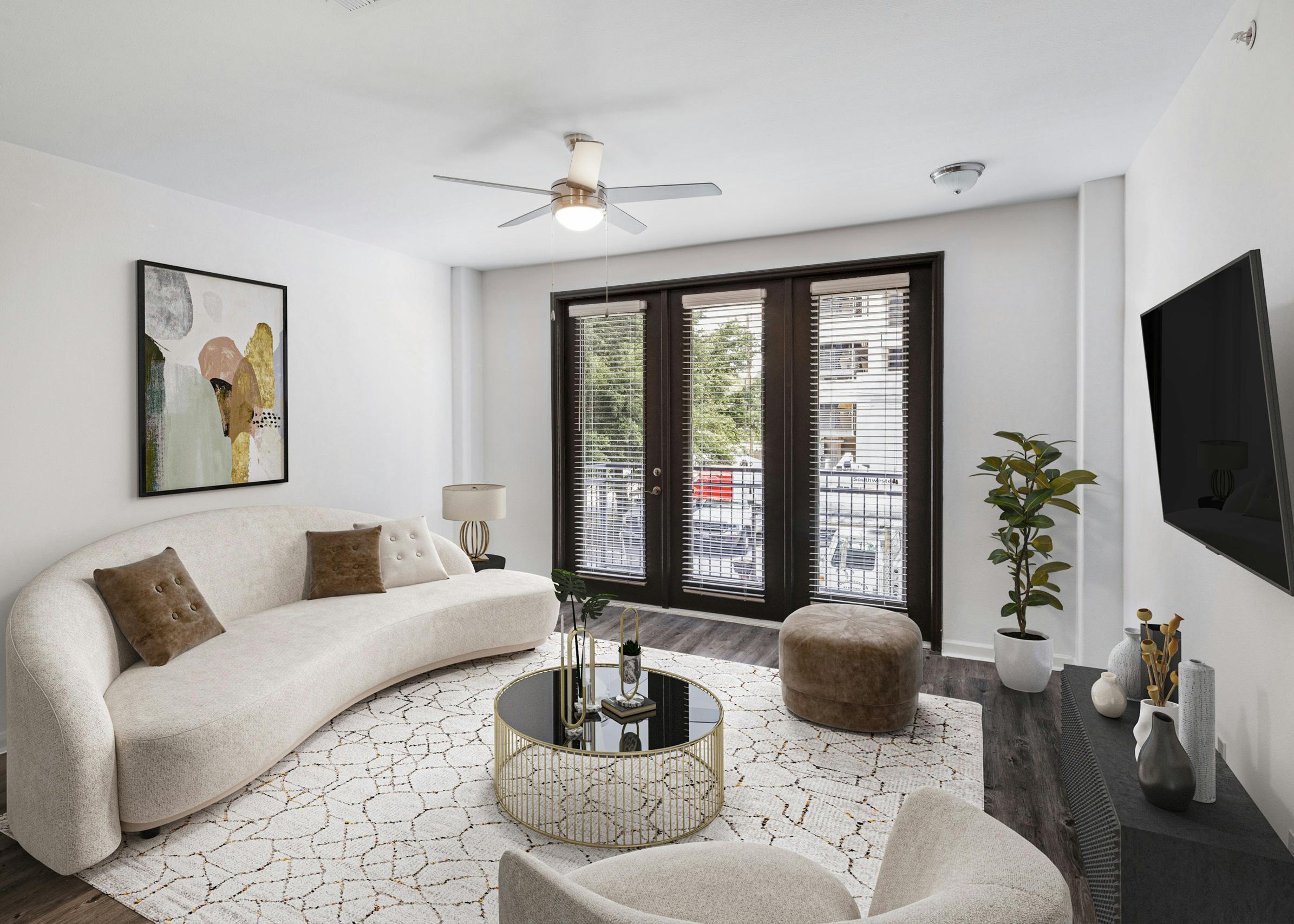 Interior view of AMLI 300 apartment living room with modern white couch with colorful artwork above and door to a balcony