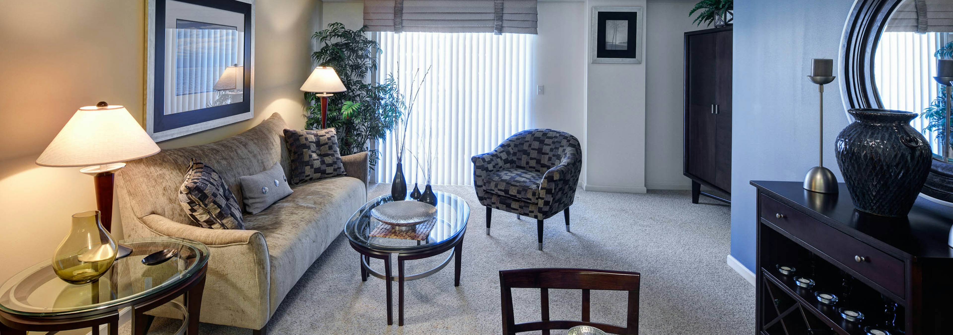 Living room at AMLI at Seven Bridges with carpeted flooring and vintage decor with a balcony door bringing in natural light