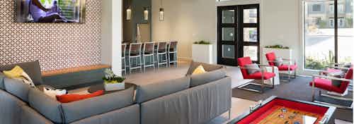 AMLI Covered Bridge resident game room and lounge with plasma TVs and kitchen with stainless steel appliances