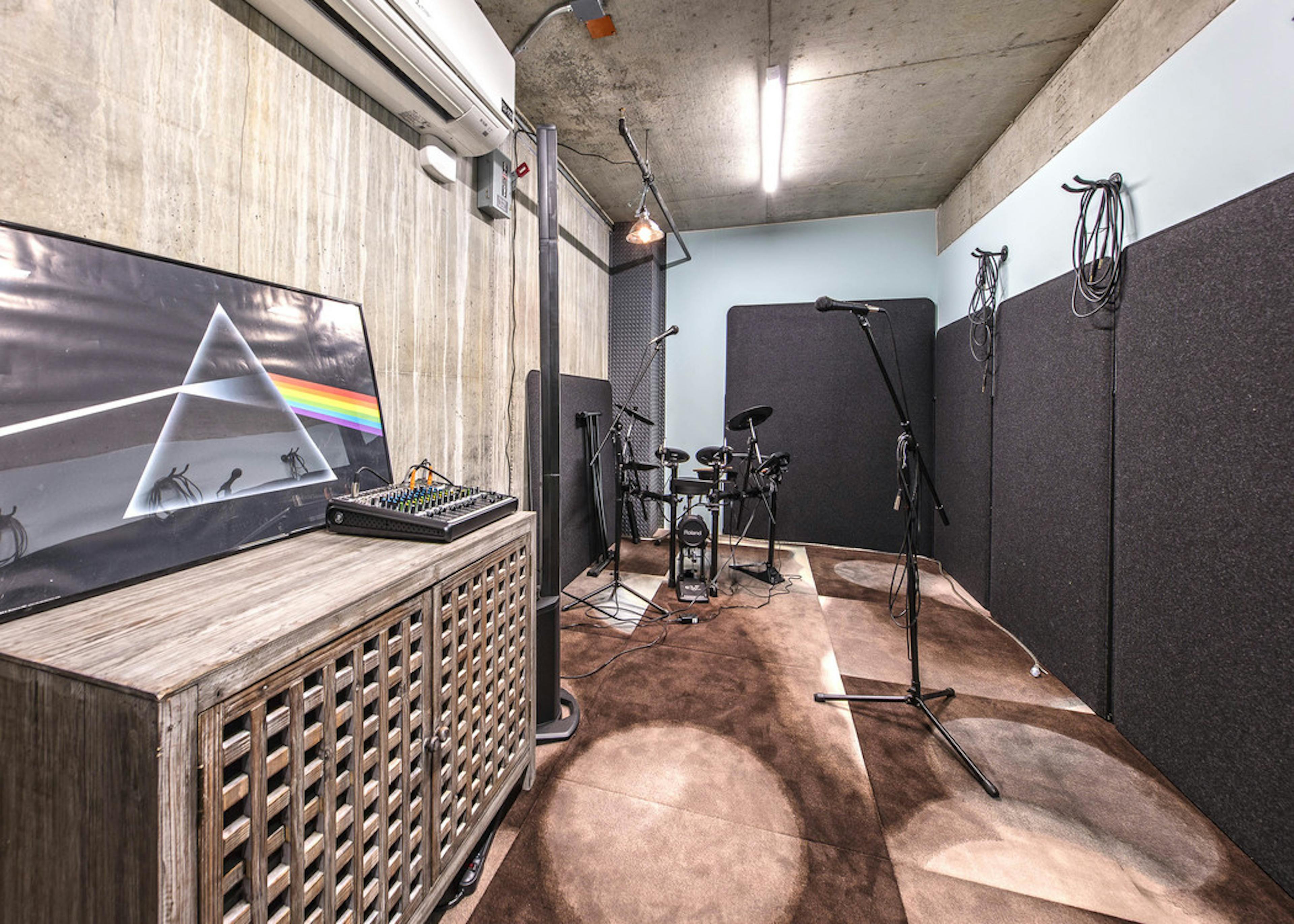 Interior music room of AMLI Arc with music soundboard microphones small electric drum set and sound proof room
